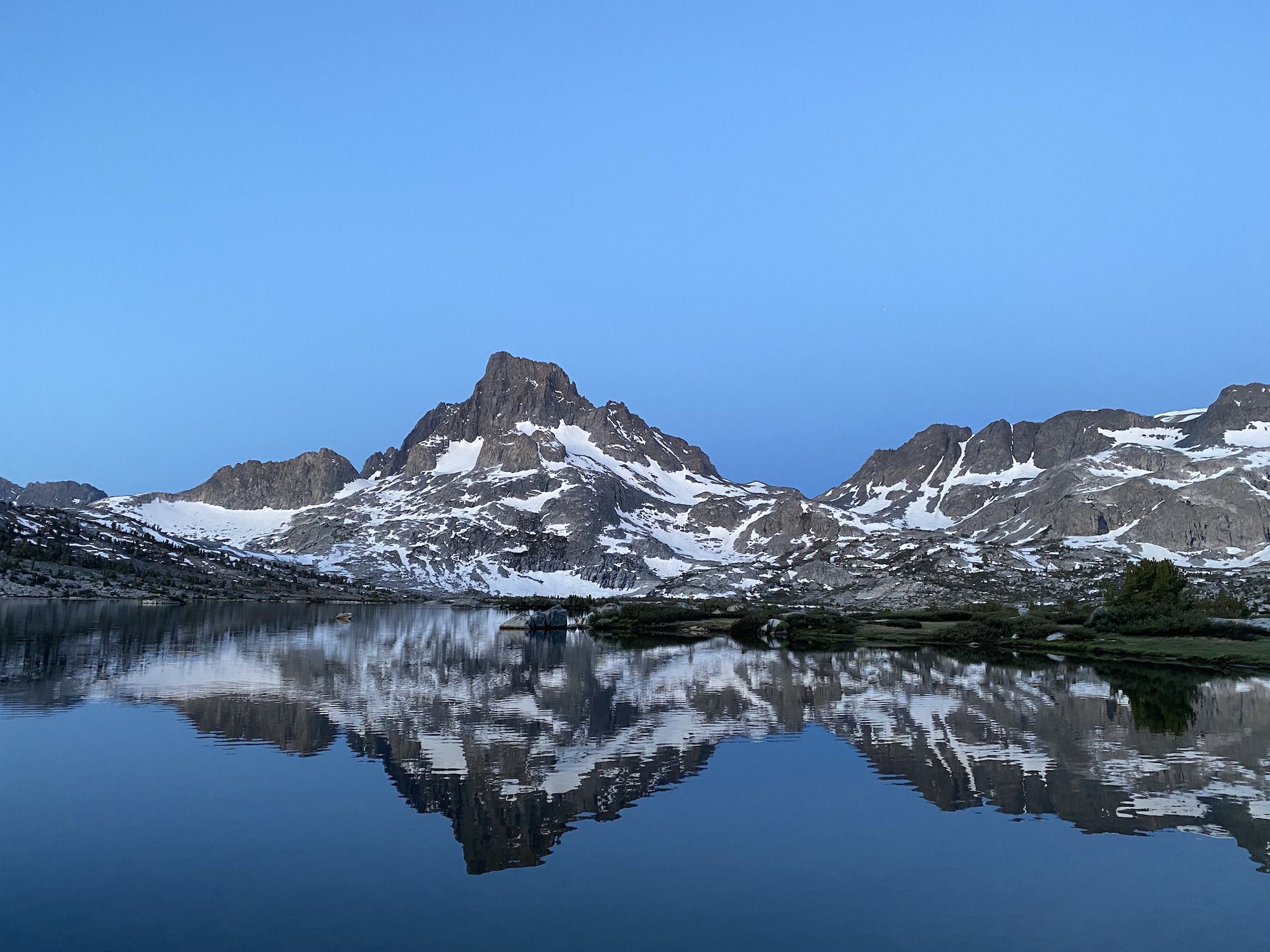 A reflection of a mountain in a calm lake