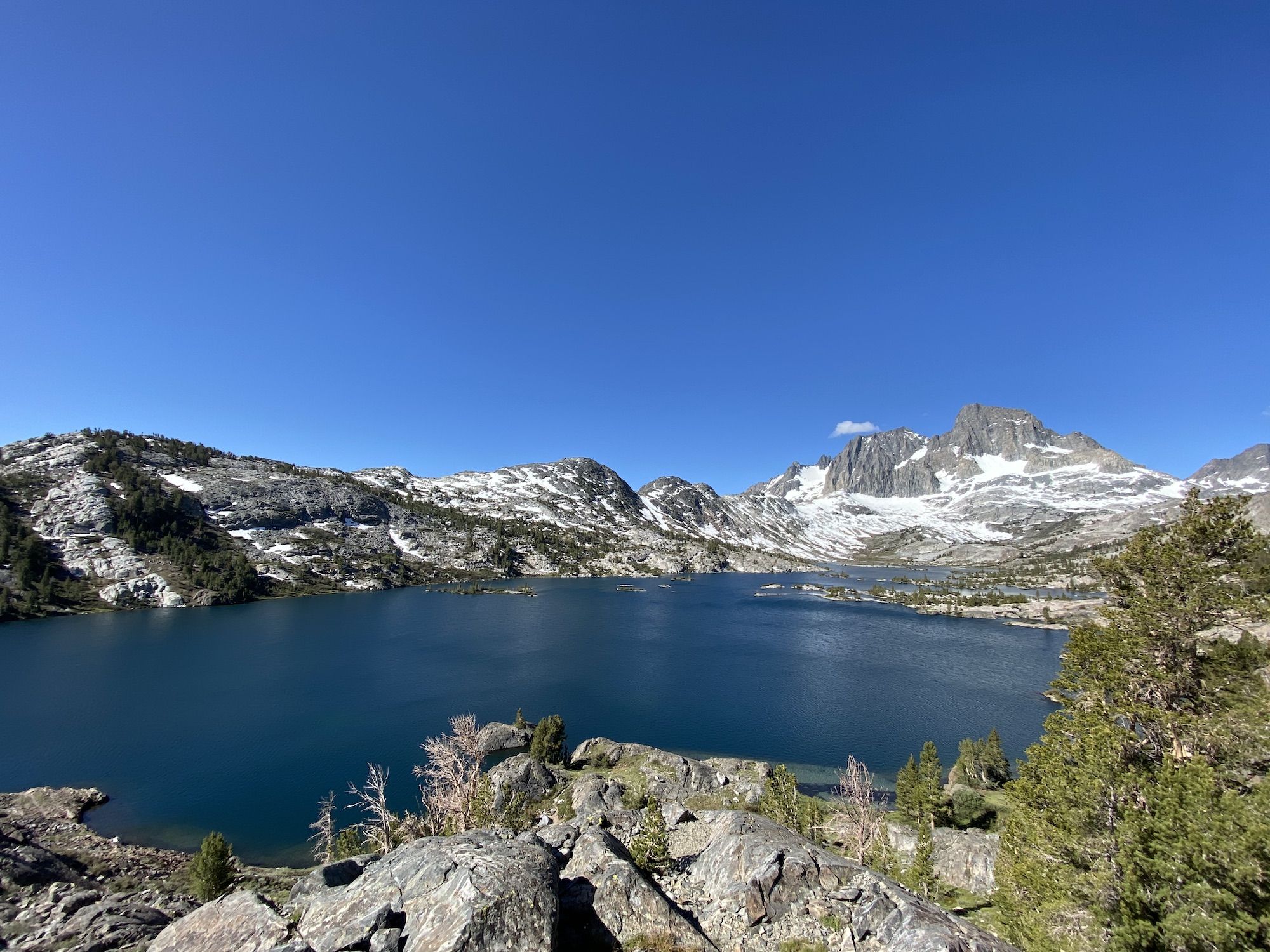 A deep blue lake in front of a mountain range