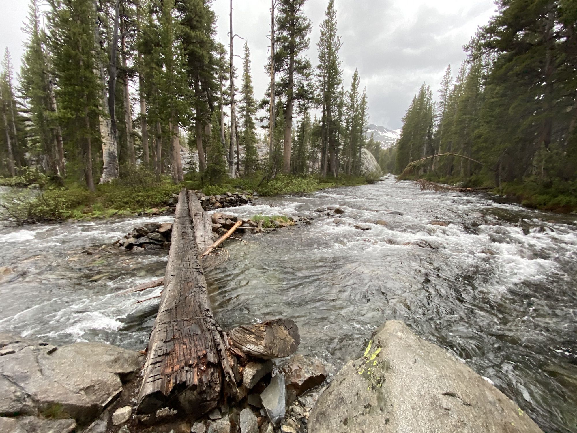 A log crossing over a raging creek