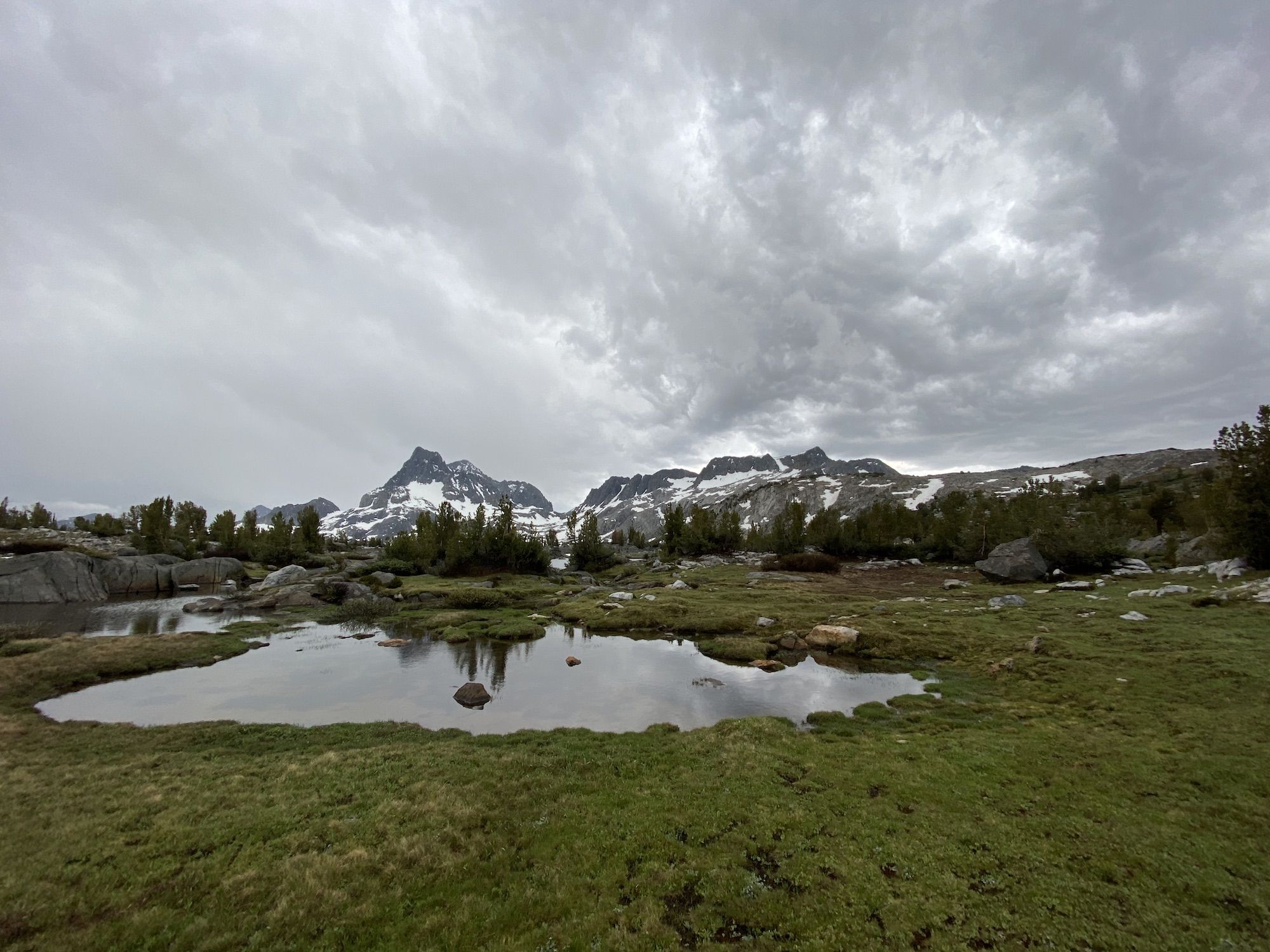 A small lake with mountains in the background