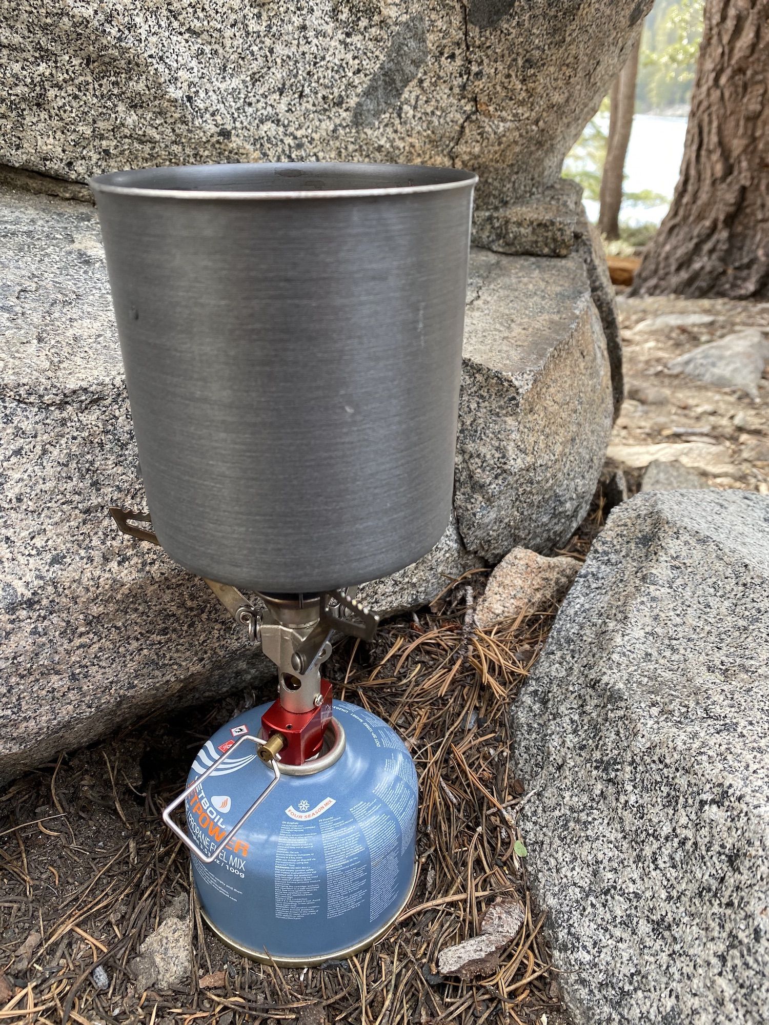 A backpacking stove with the macaroni pot on top.