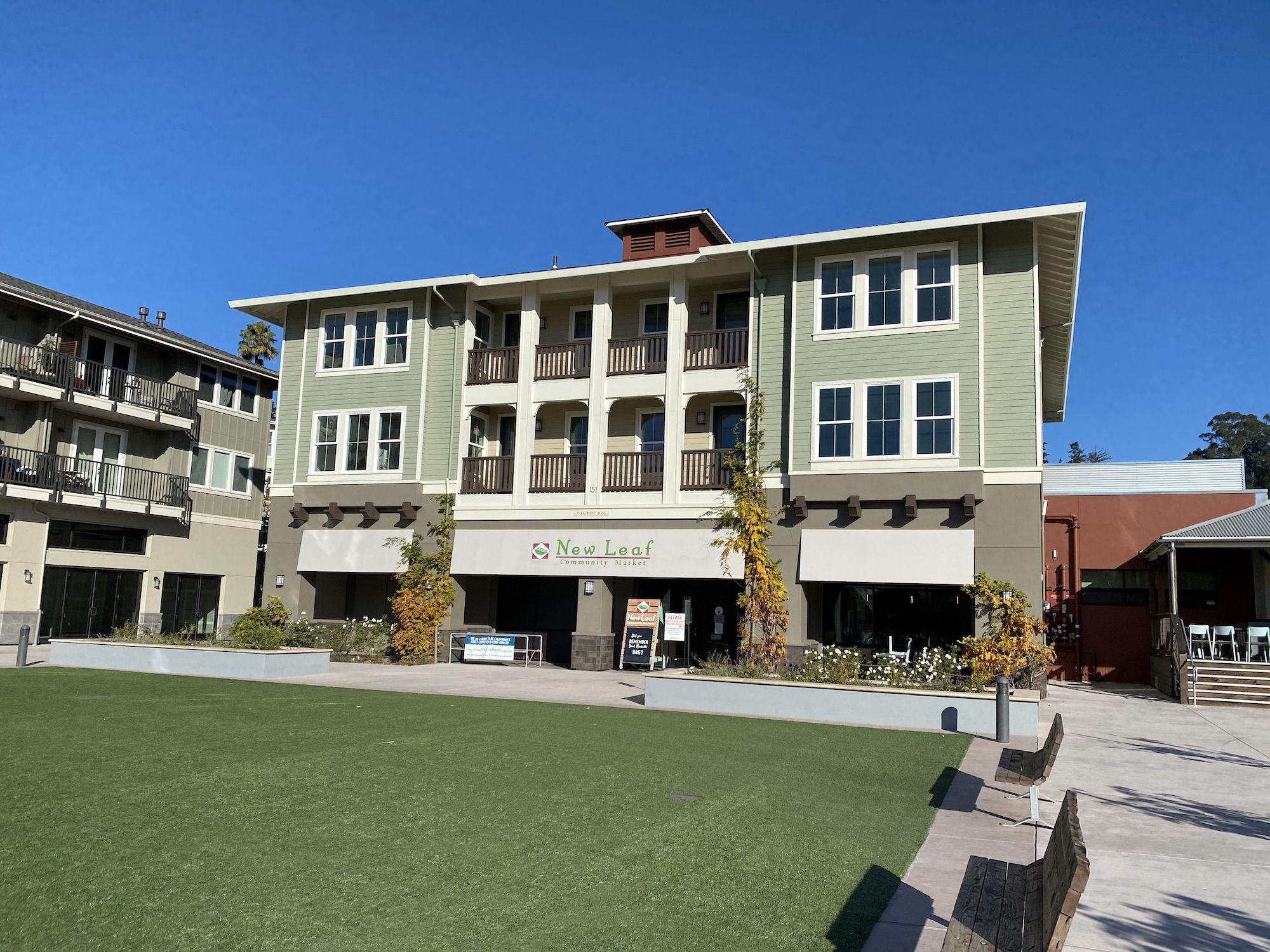 A courtyard with a lawn surrounded by benches. 