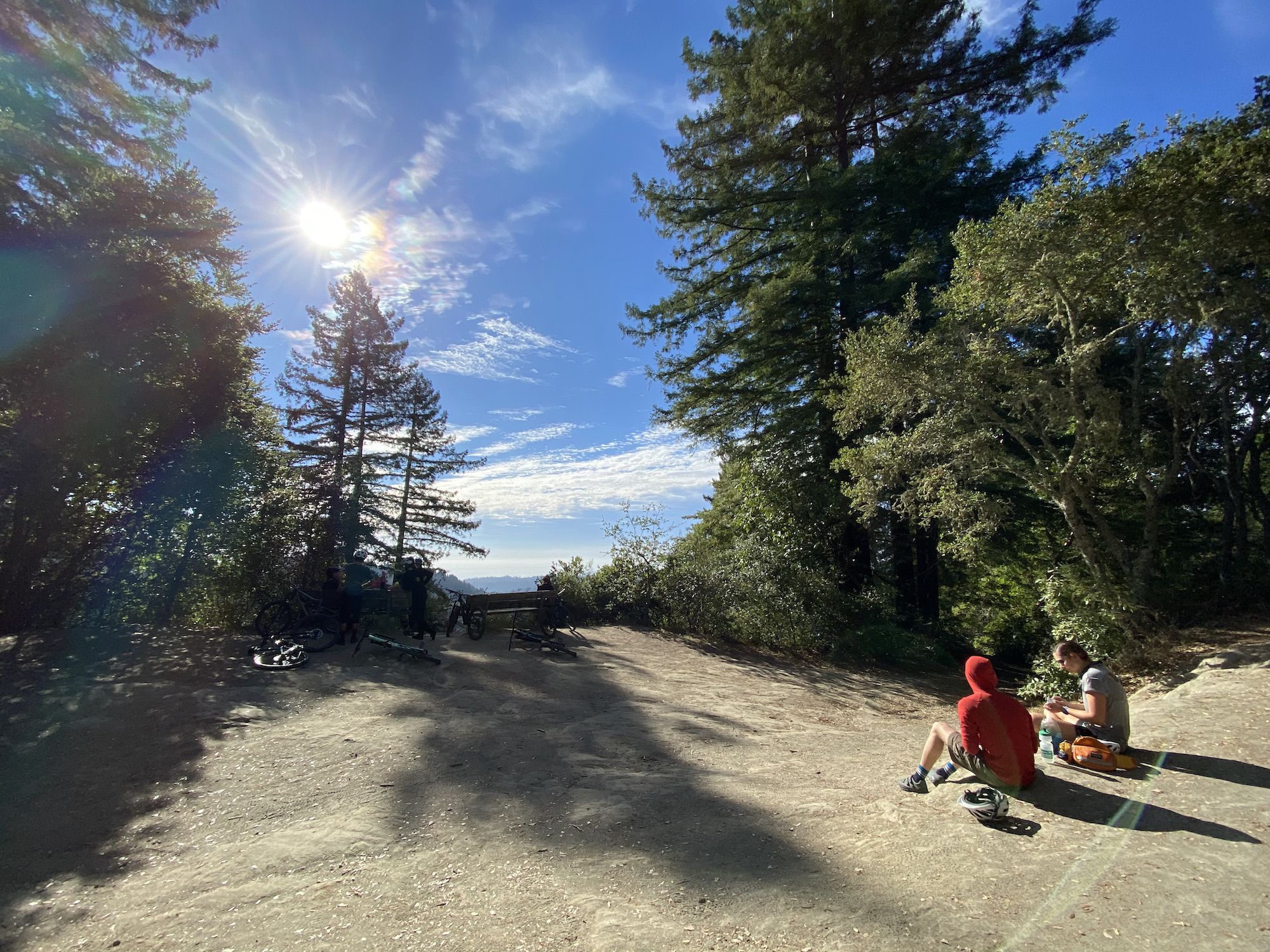 People sitting at an overlook with views of the distant ocean. 