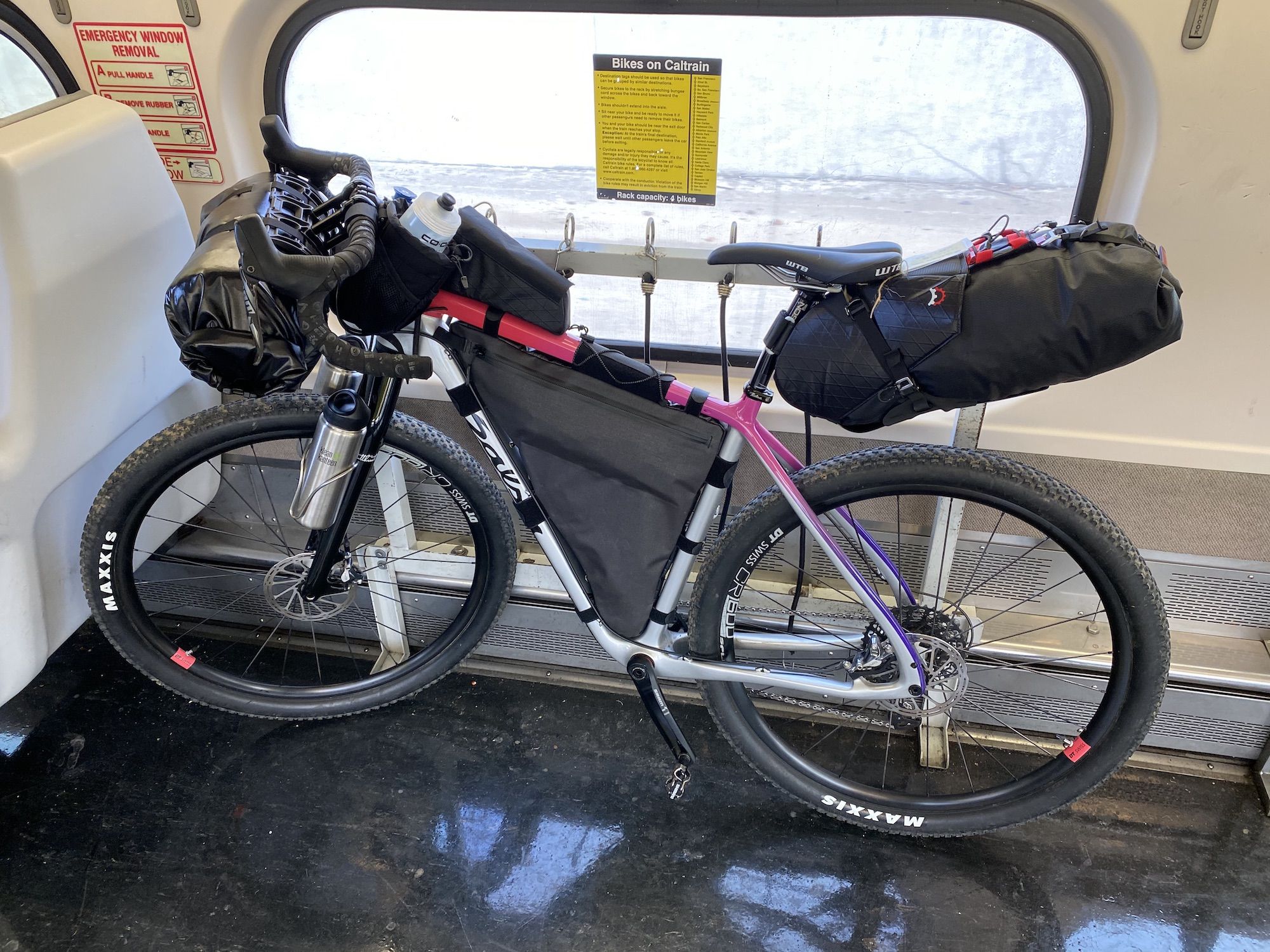 A bike with bikepacking bags loaded onto a train. Caltrain is a good option to get to the start of your trip in the Bay Area.