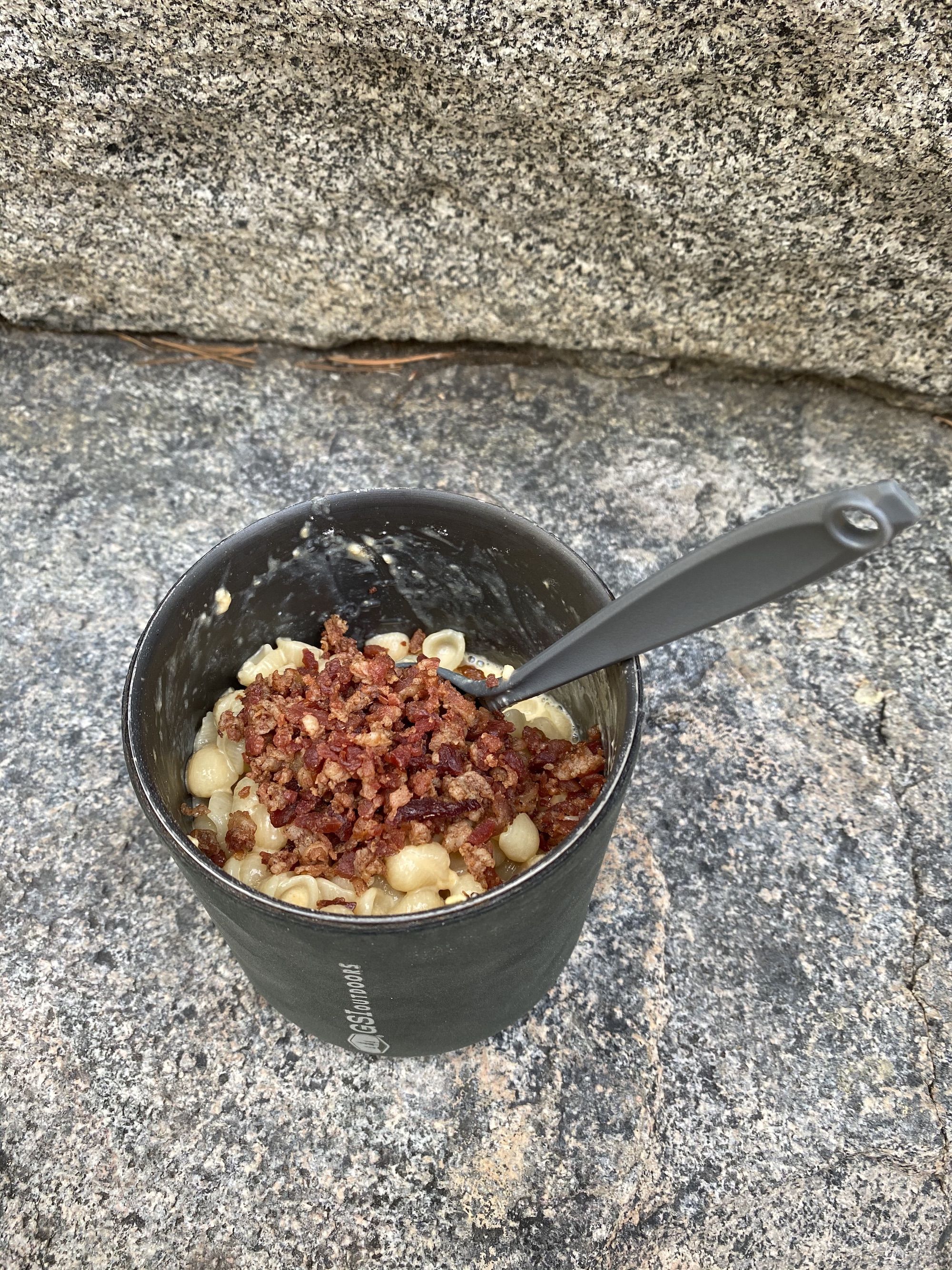 A pot with mac n cheese with bacon on top