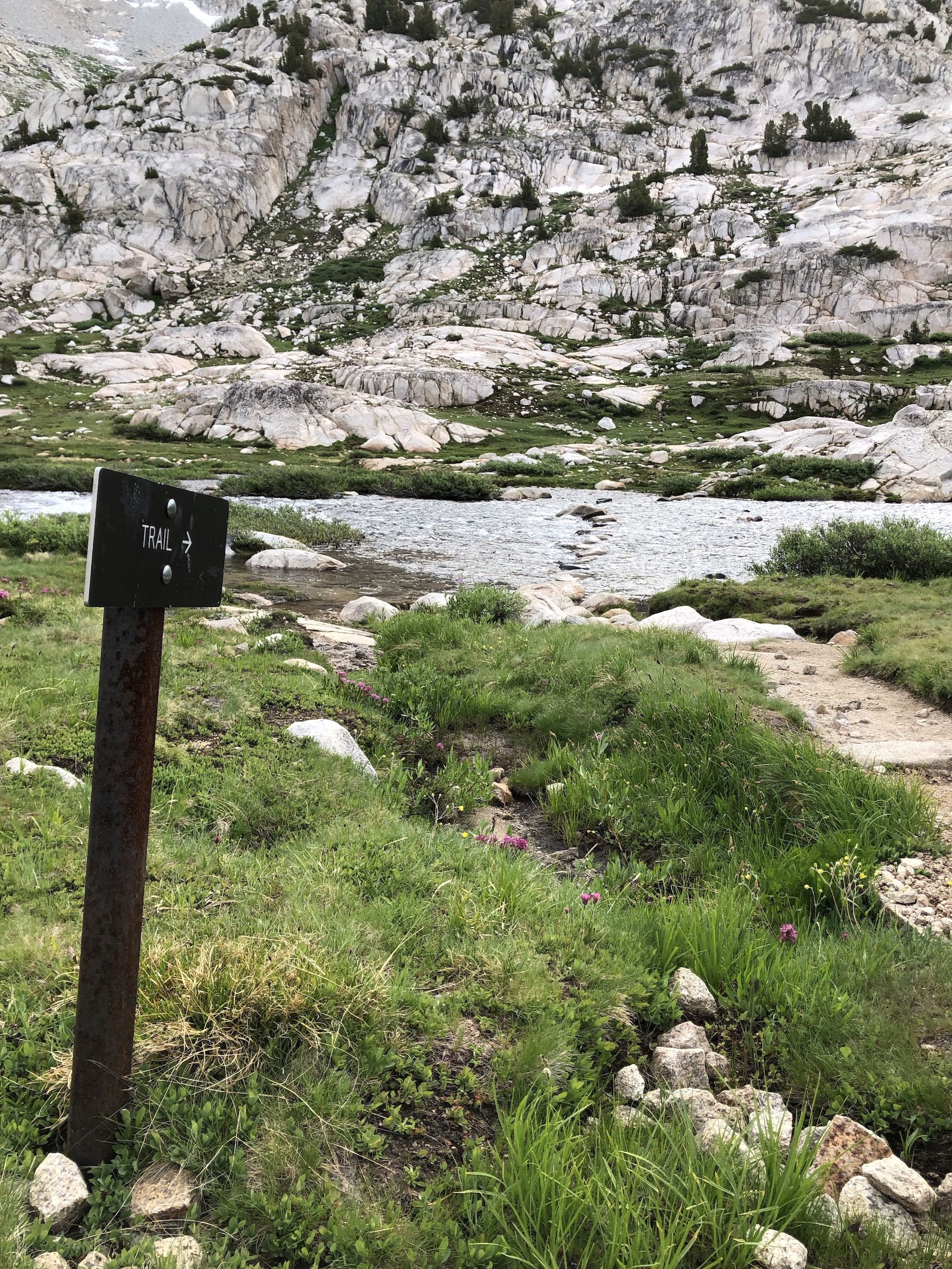 Trail post pointing across a river