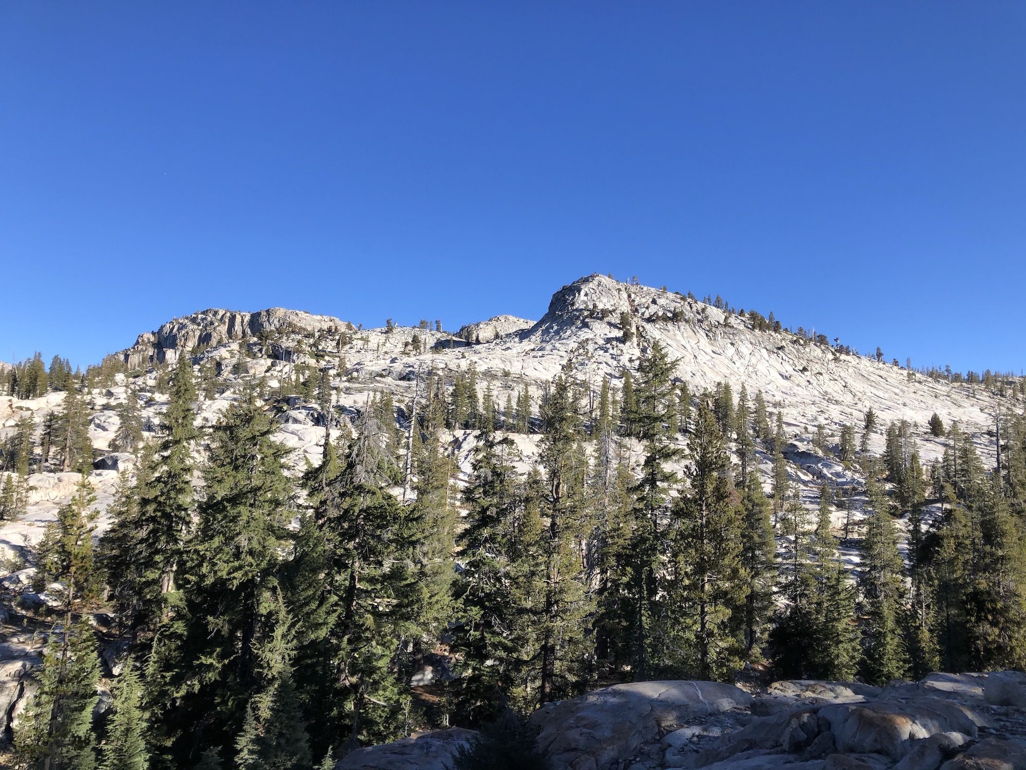 A glacial granite peak, smooth on one side and dropping sharply on the other side.