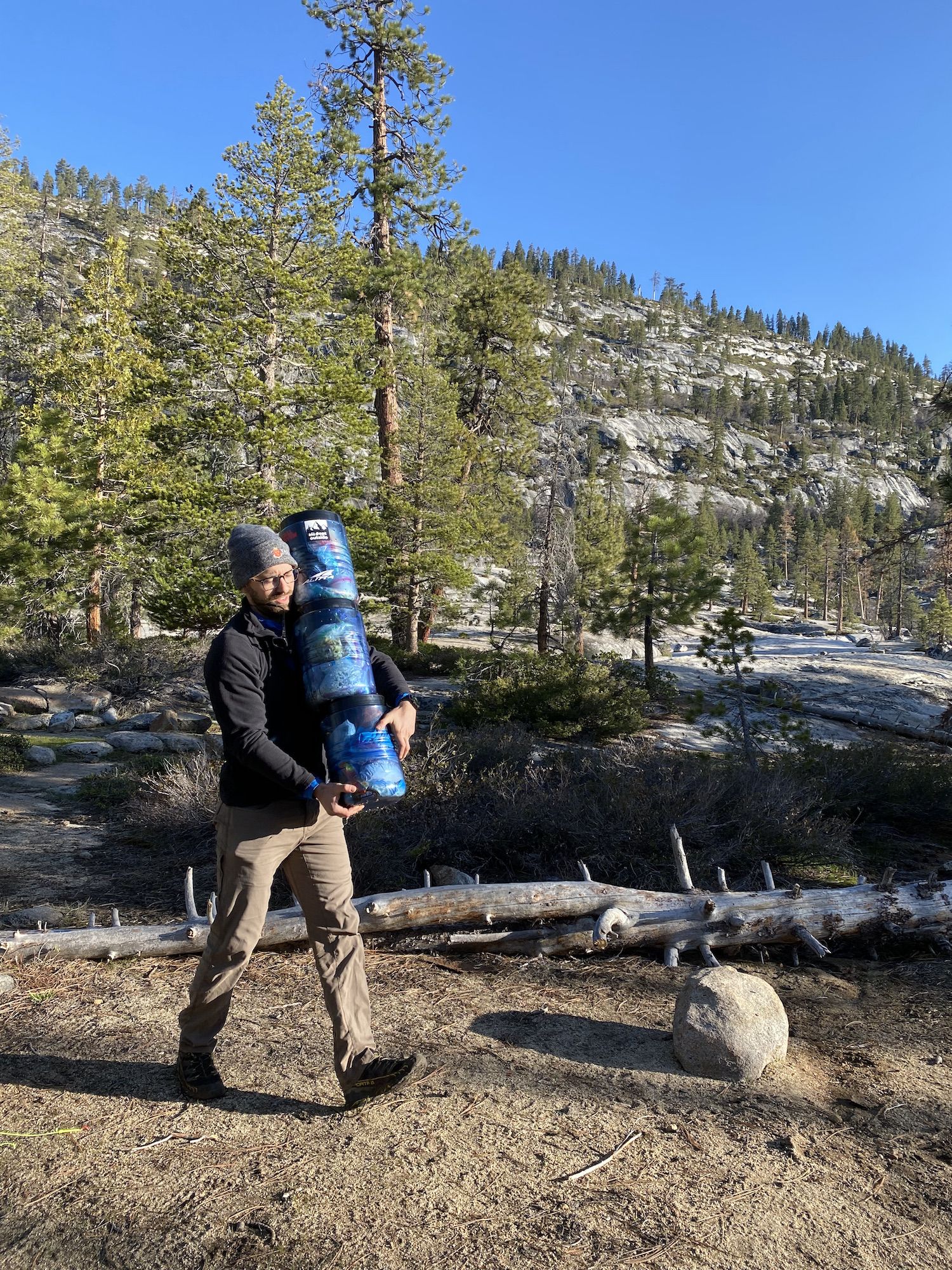 Man carrying 3 bear canisters