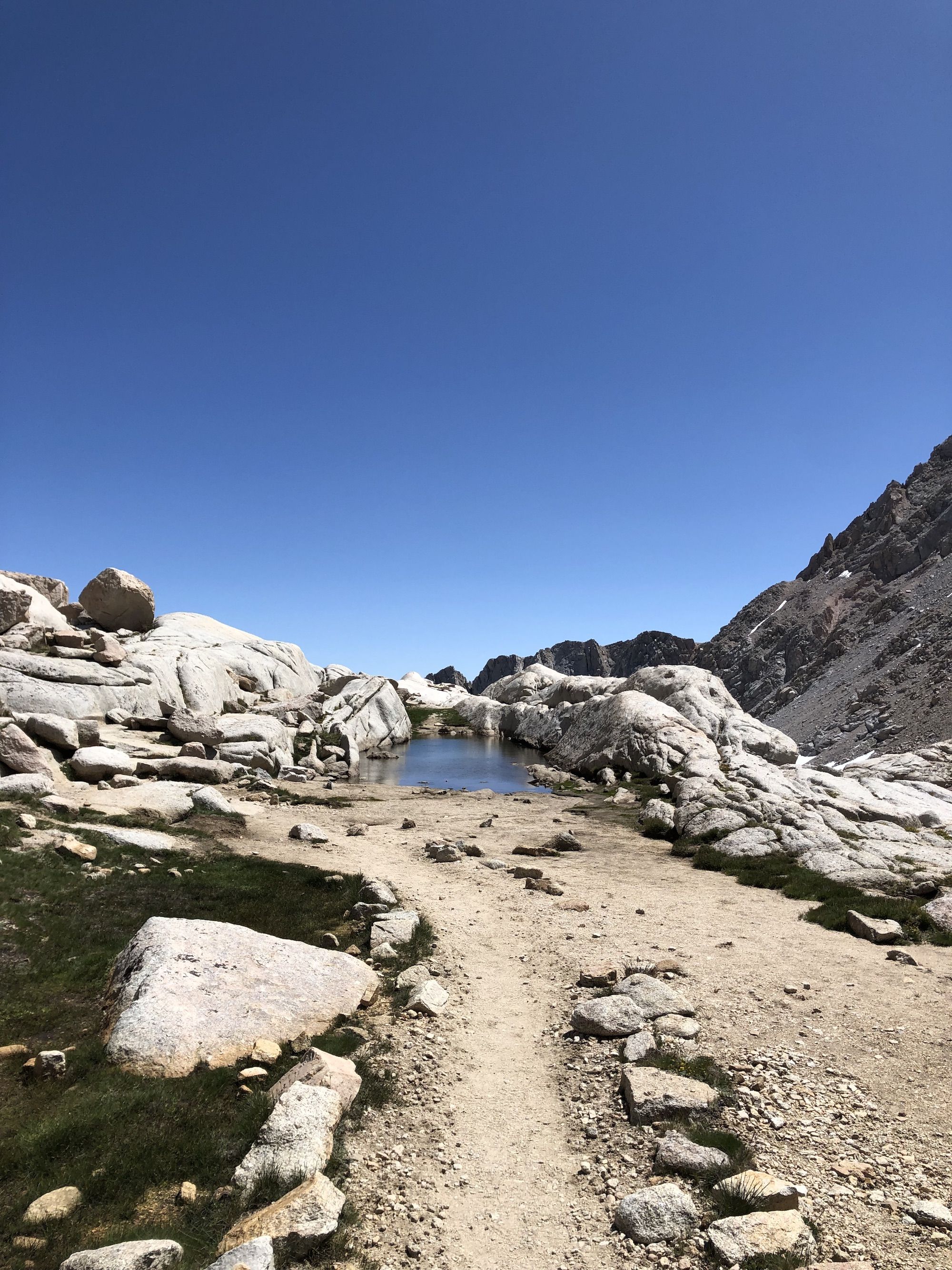 A small pond nestled in a granite mountain.