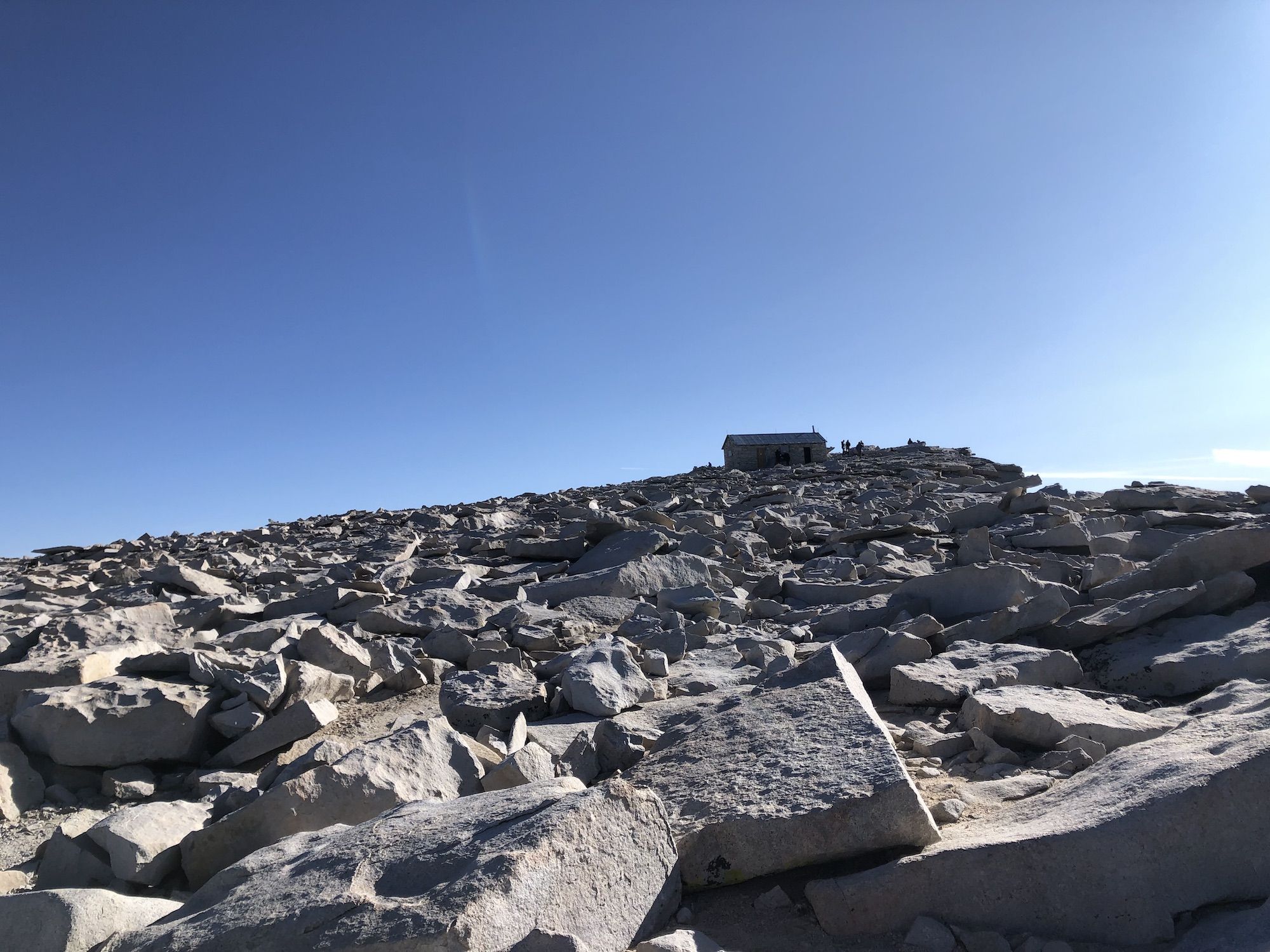 A mountain hut at the top of a mountain.