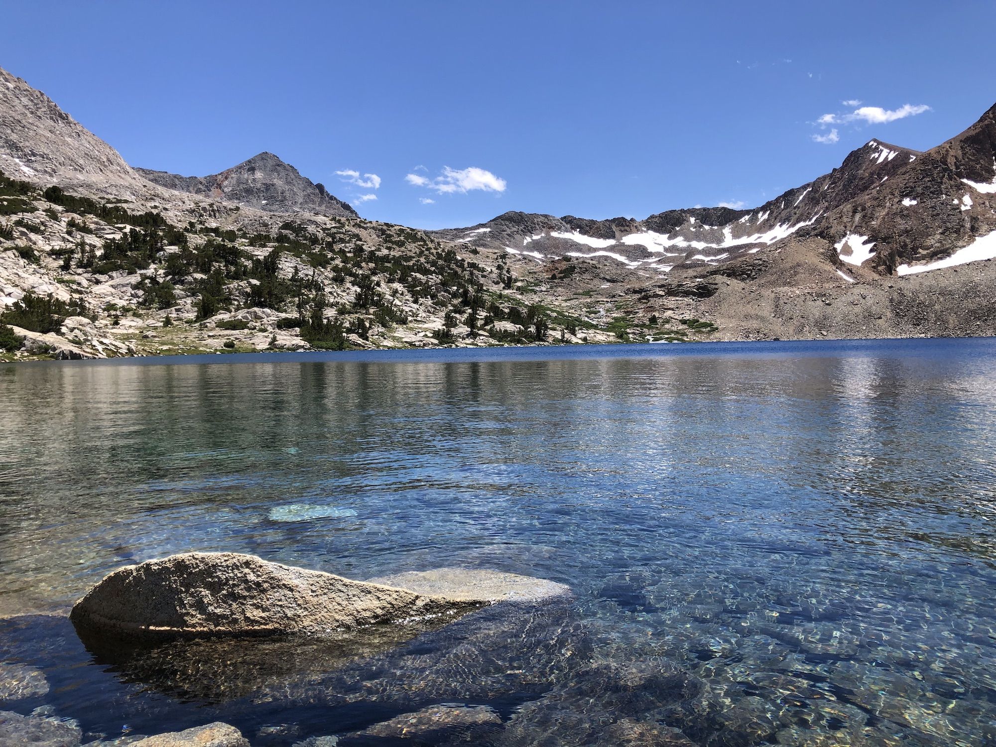 A deep ocean blue lake surrounded by mountains.