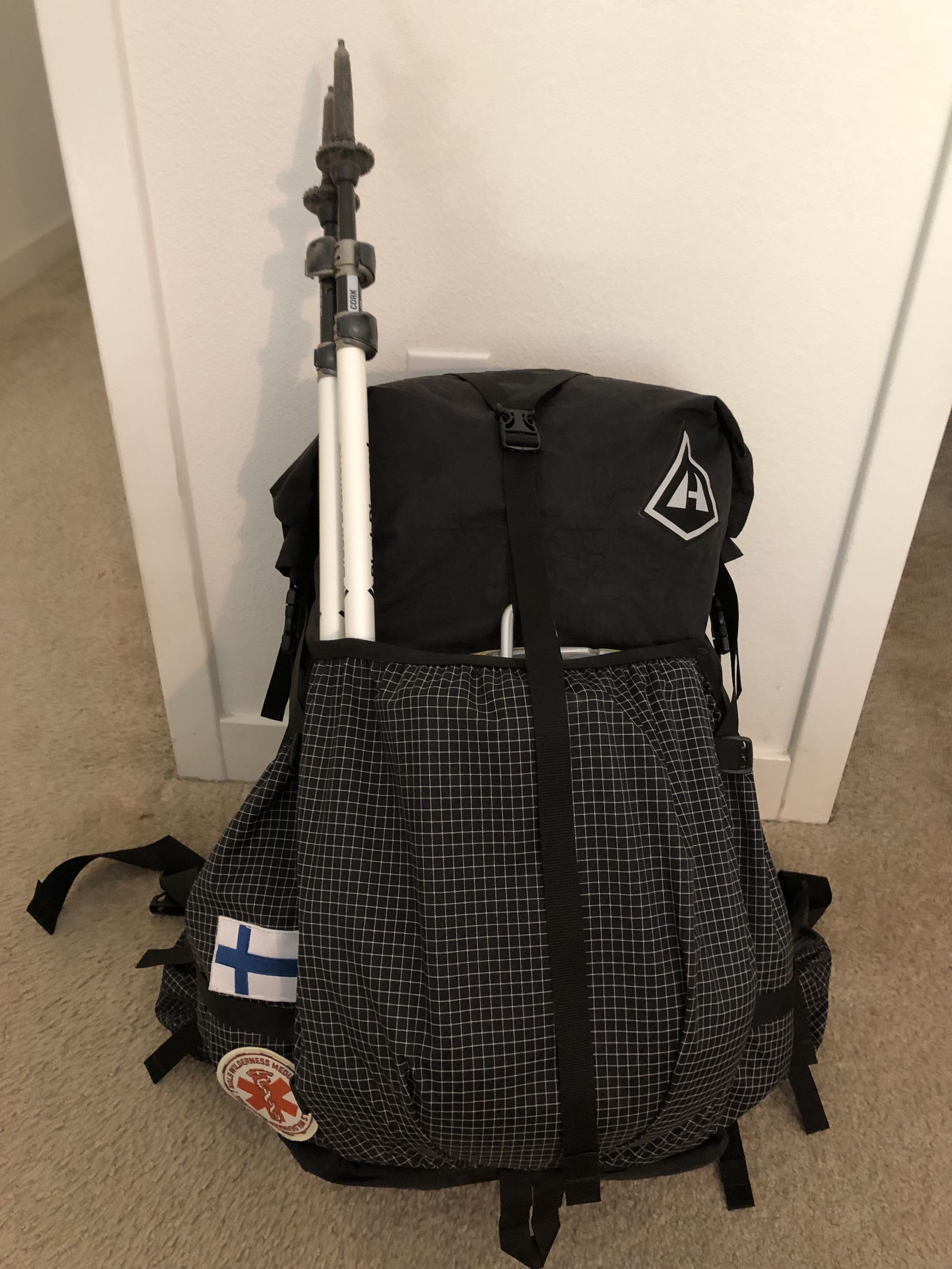 Backpack with hiking poles in the back pocket.