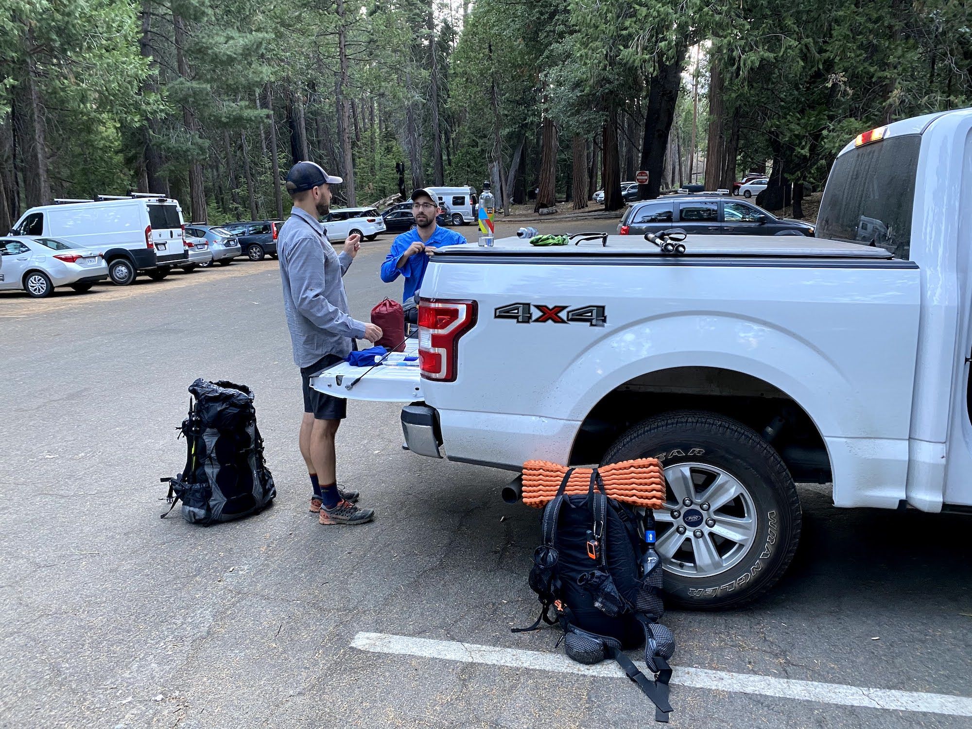 Two men getting their backpacking gear in order at the Road's End trailhead in Kings Canyon