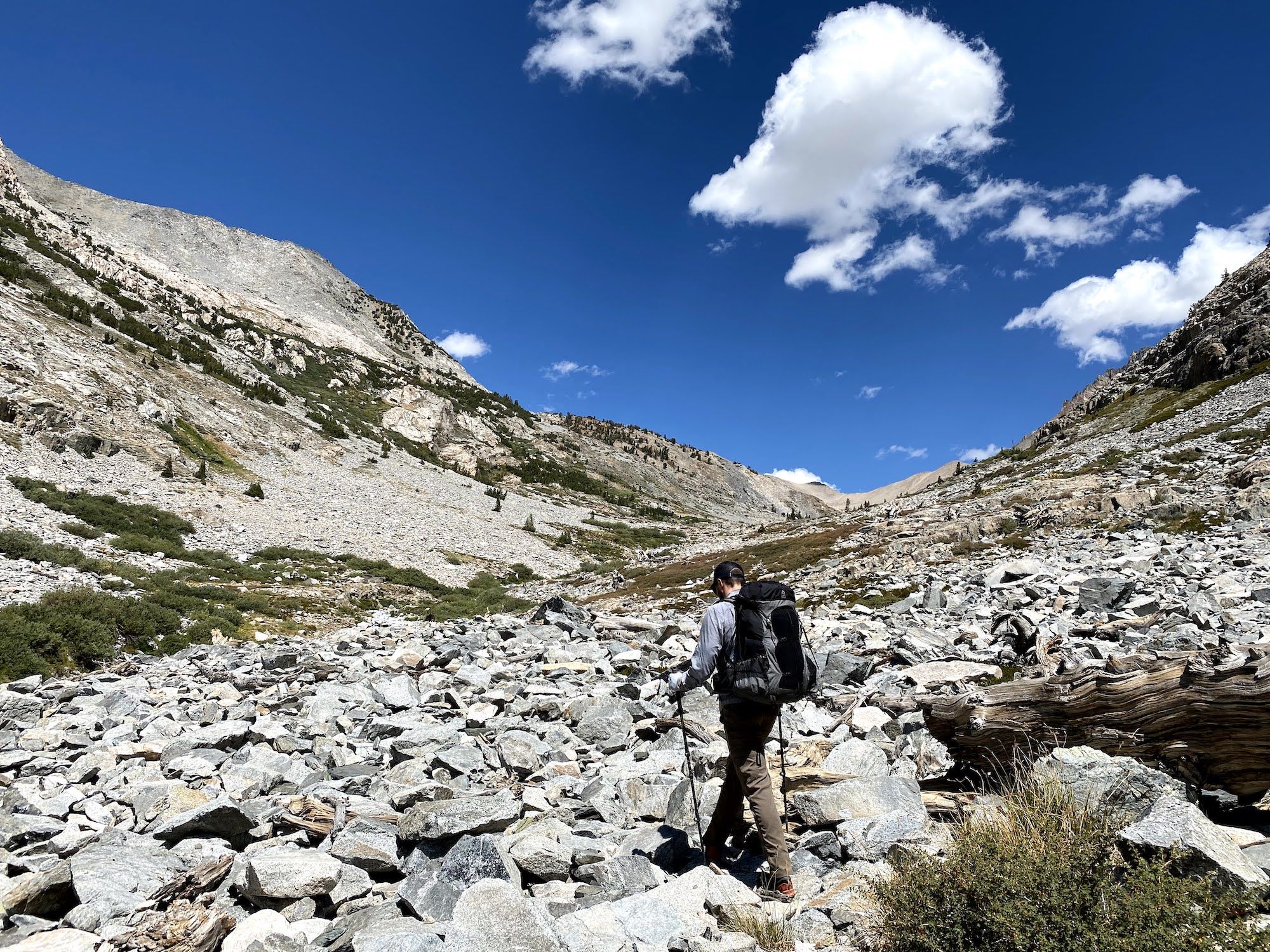 A man walking over a talus field along White Fork 