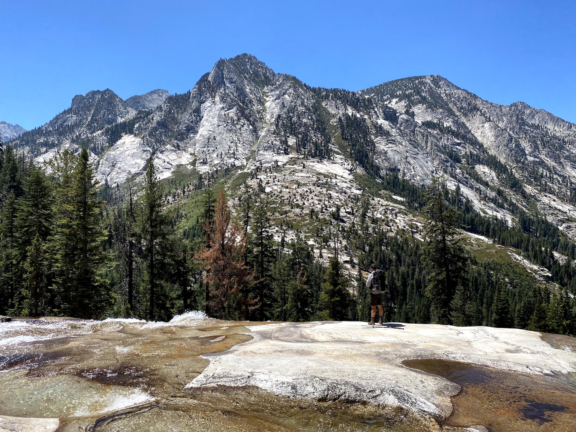 A man standing on top of a granite waterall in Kings Canyon