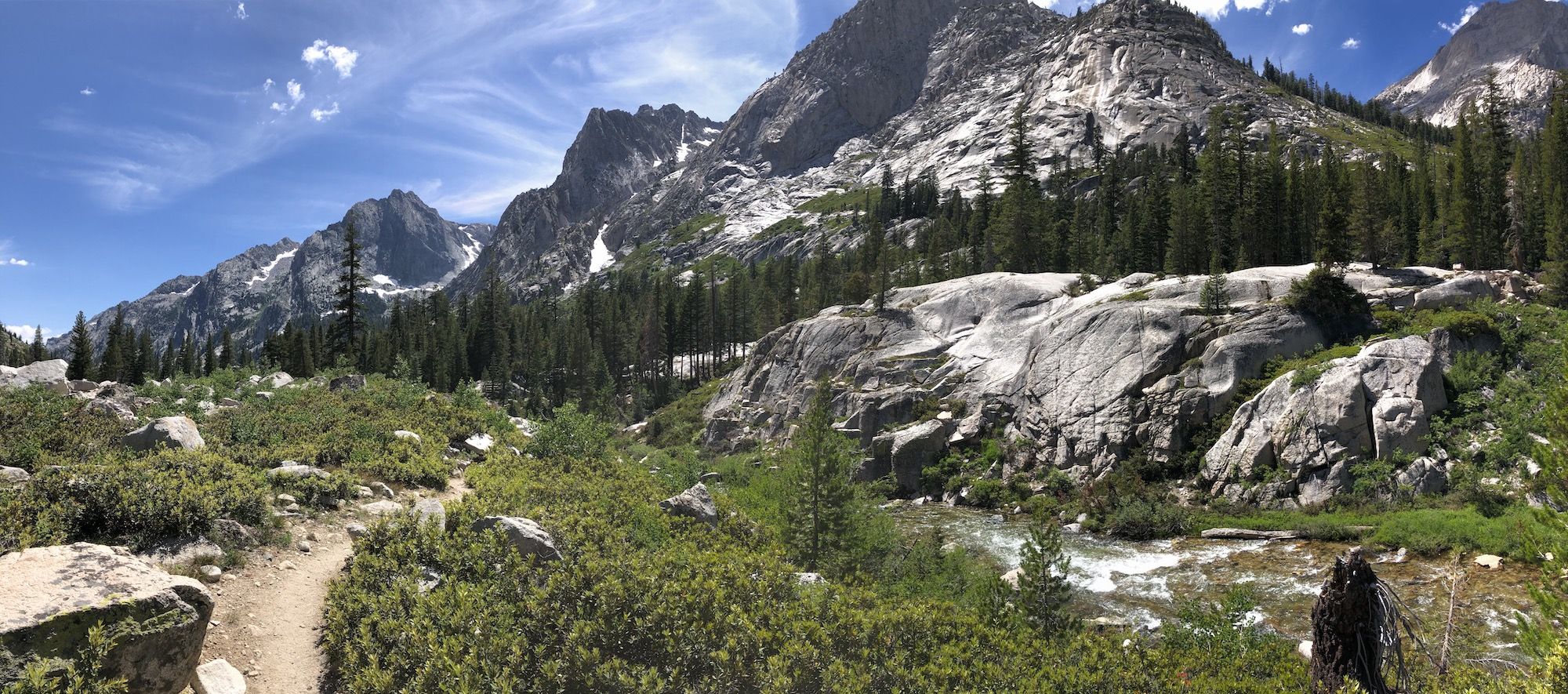 Towering granite peaks on the right side of a trail