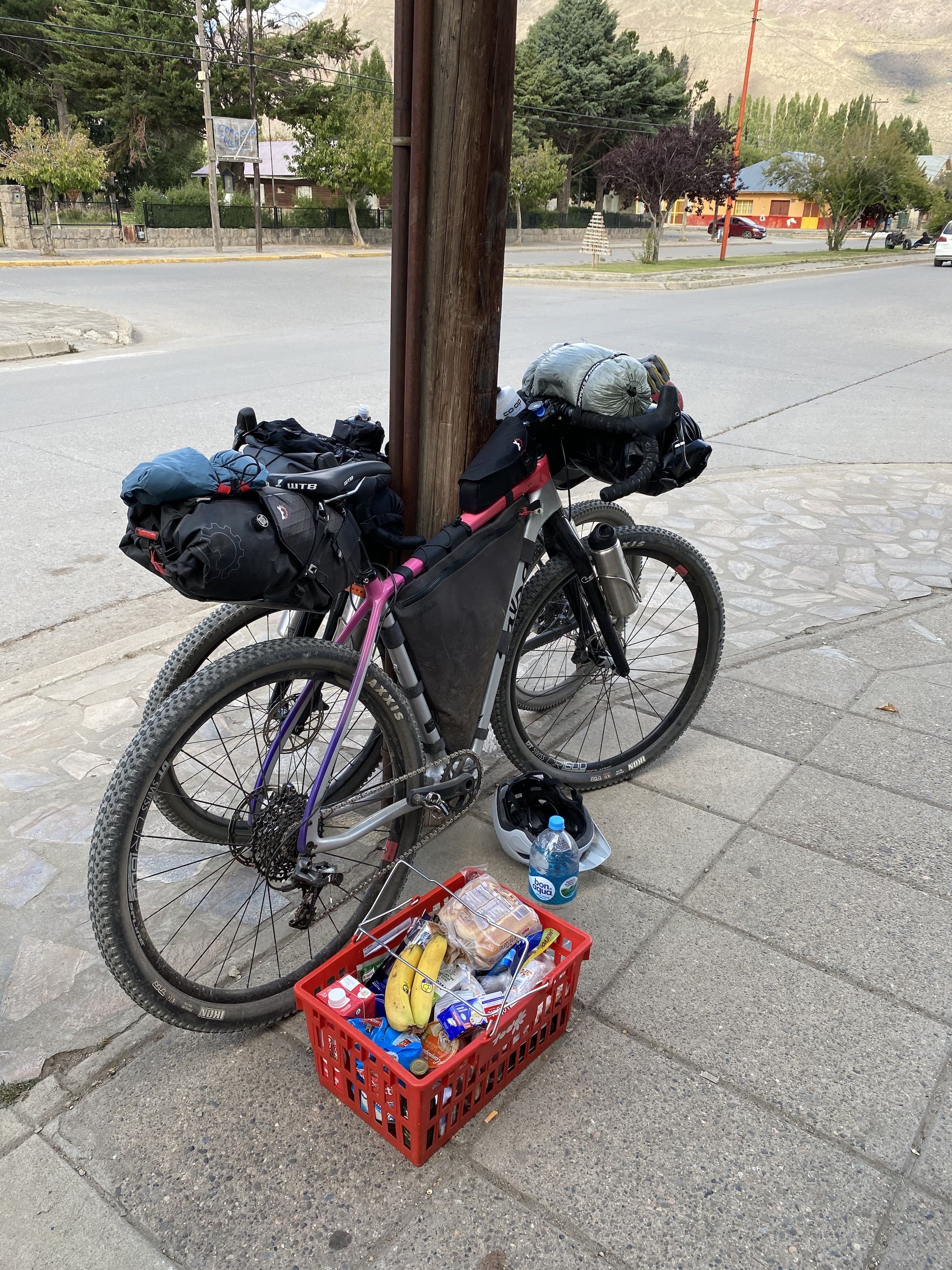 A full shopping basket next to bikes. 