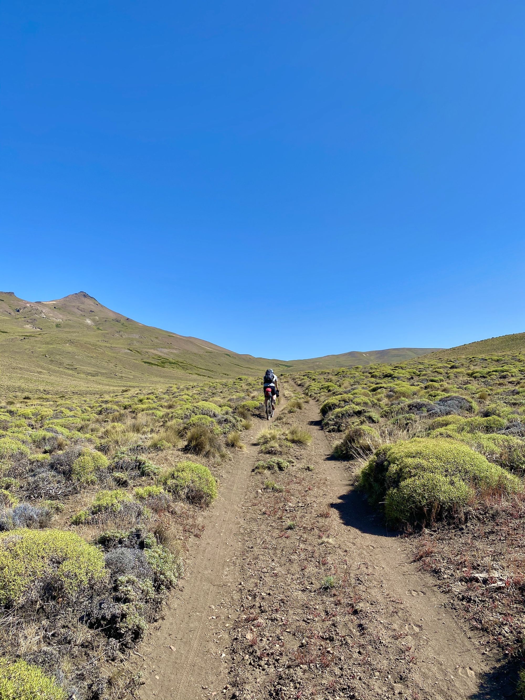 Man riding a bike up a dirt road