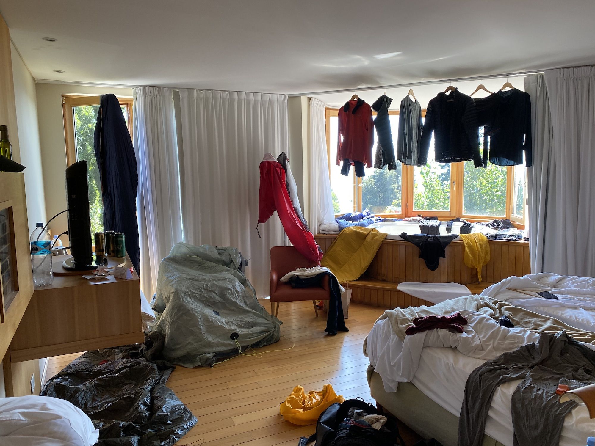 Clothes and gear spread around a hotel room to dry
