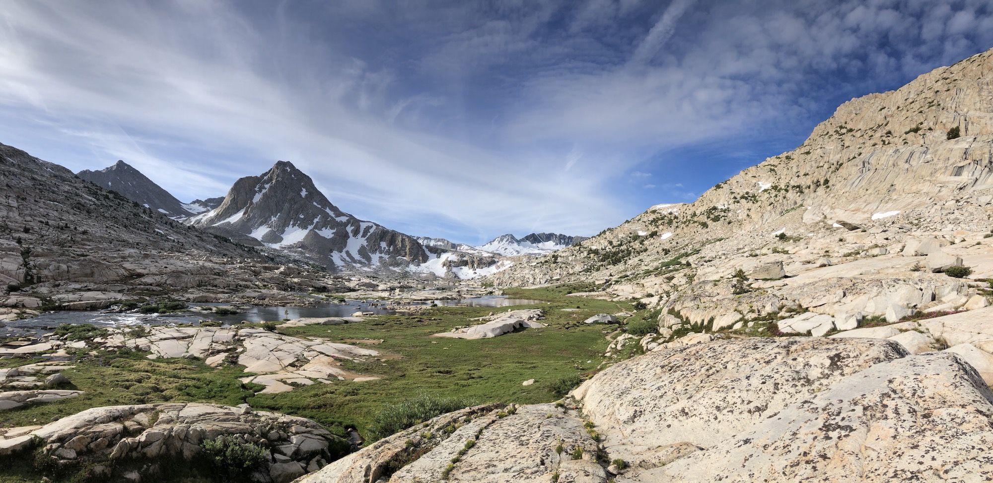 High alpine basin with small ponds and snow-covered mountains