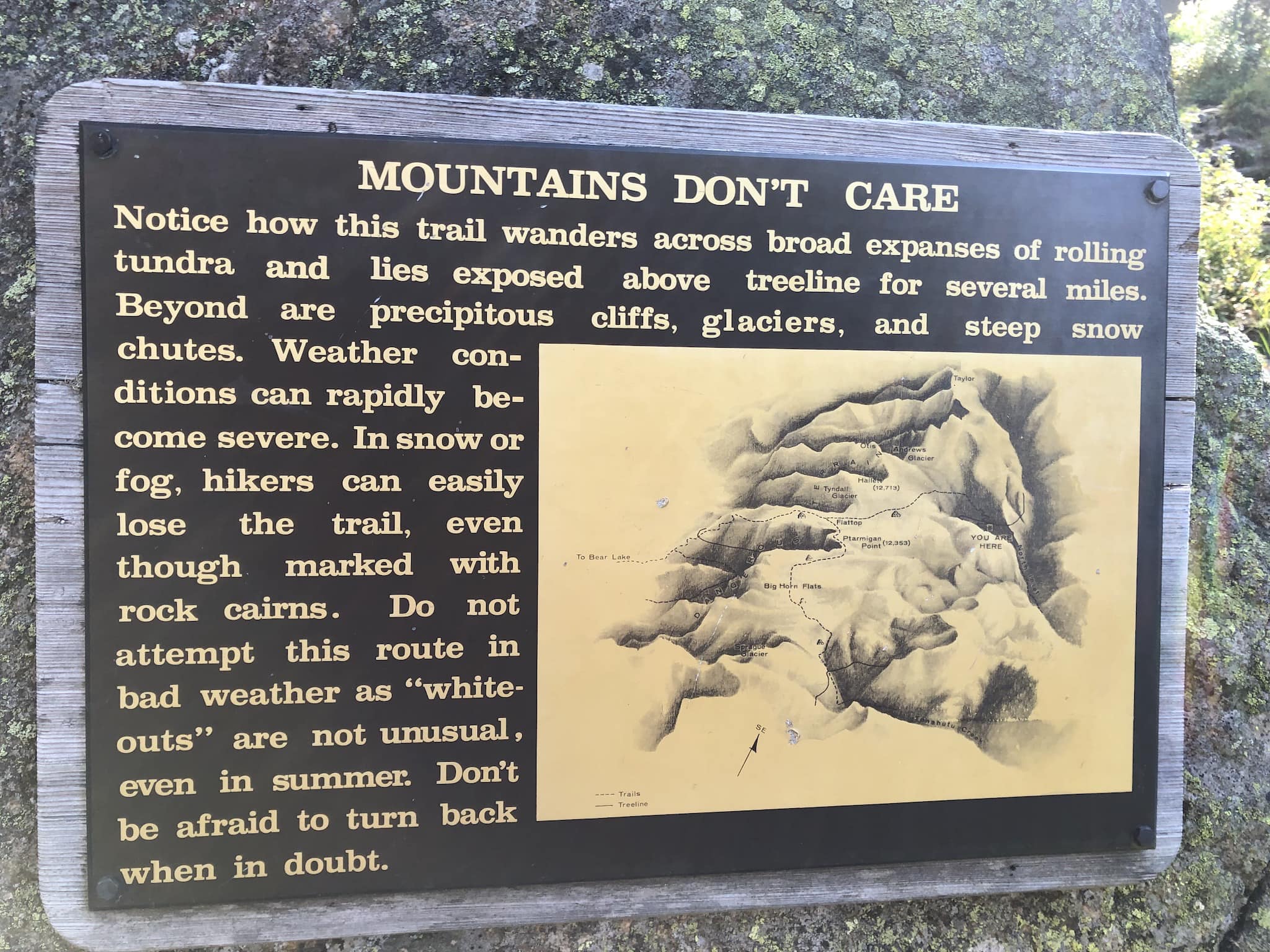 A sign warning hikers about the dangerous weather conditions ahead.