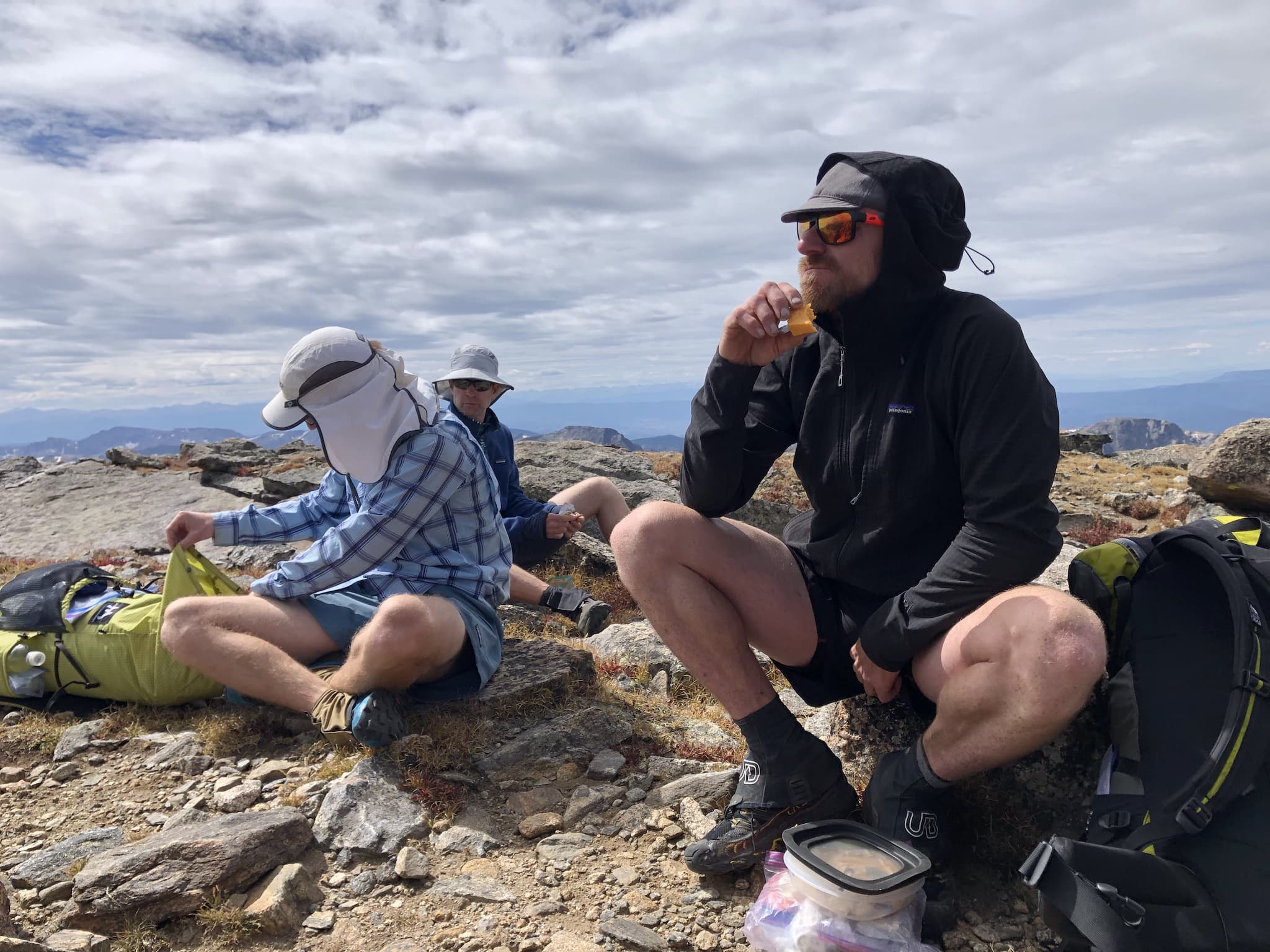 Three men eating snacks.
