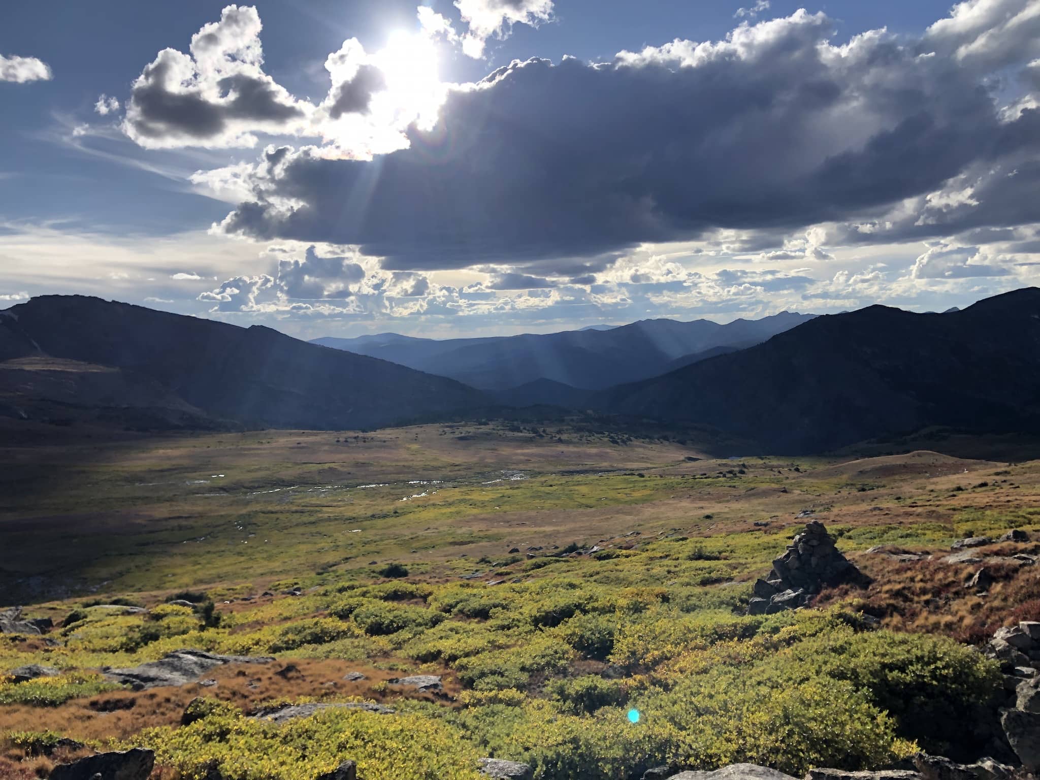 Rays of sun illuminating a valley with a small stream