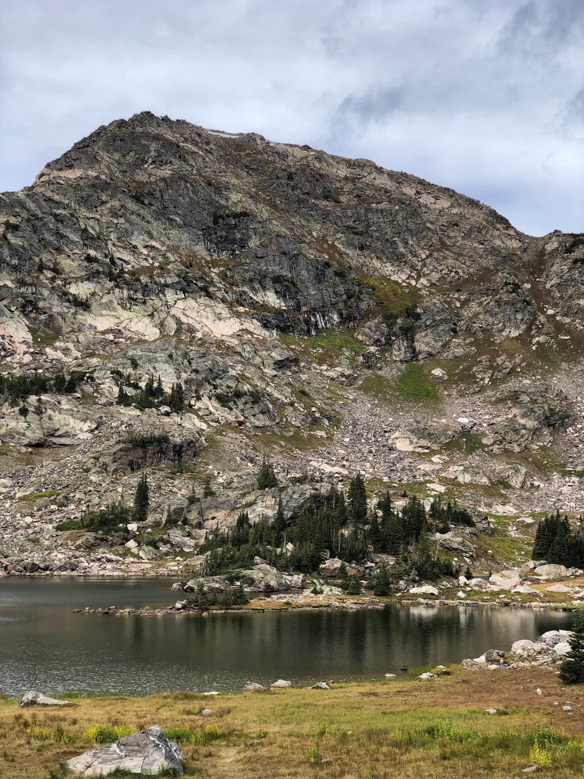 A granite mountain behind an alpine lake
