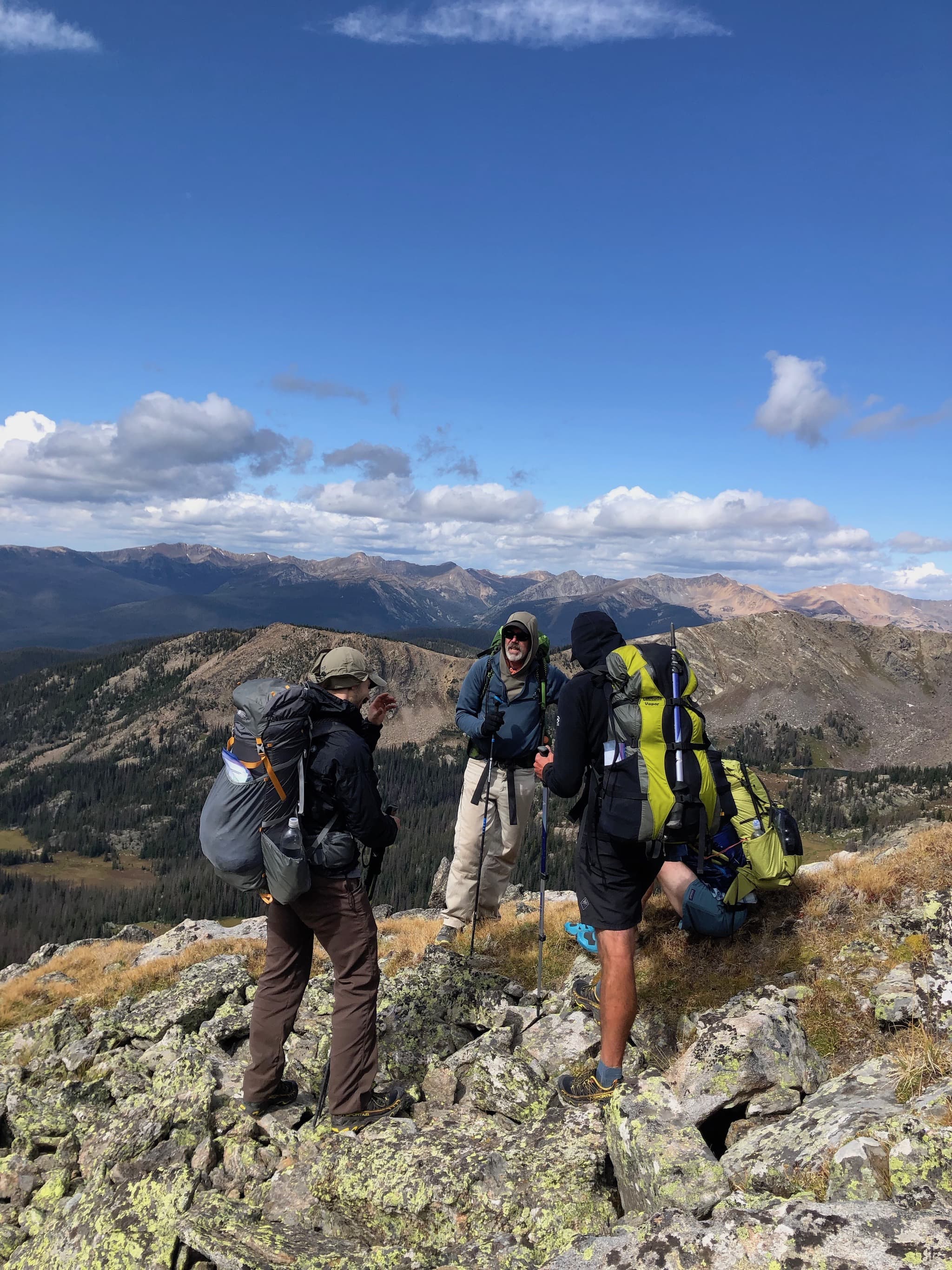 A group of backpackers standing on the top of a ridge.