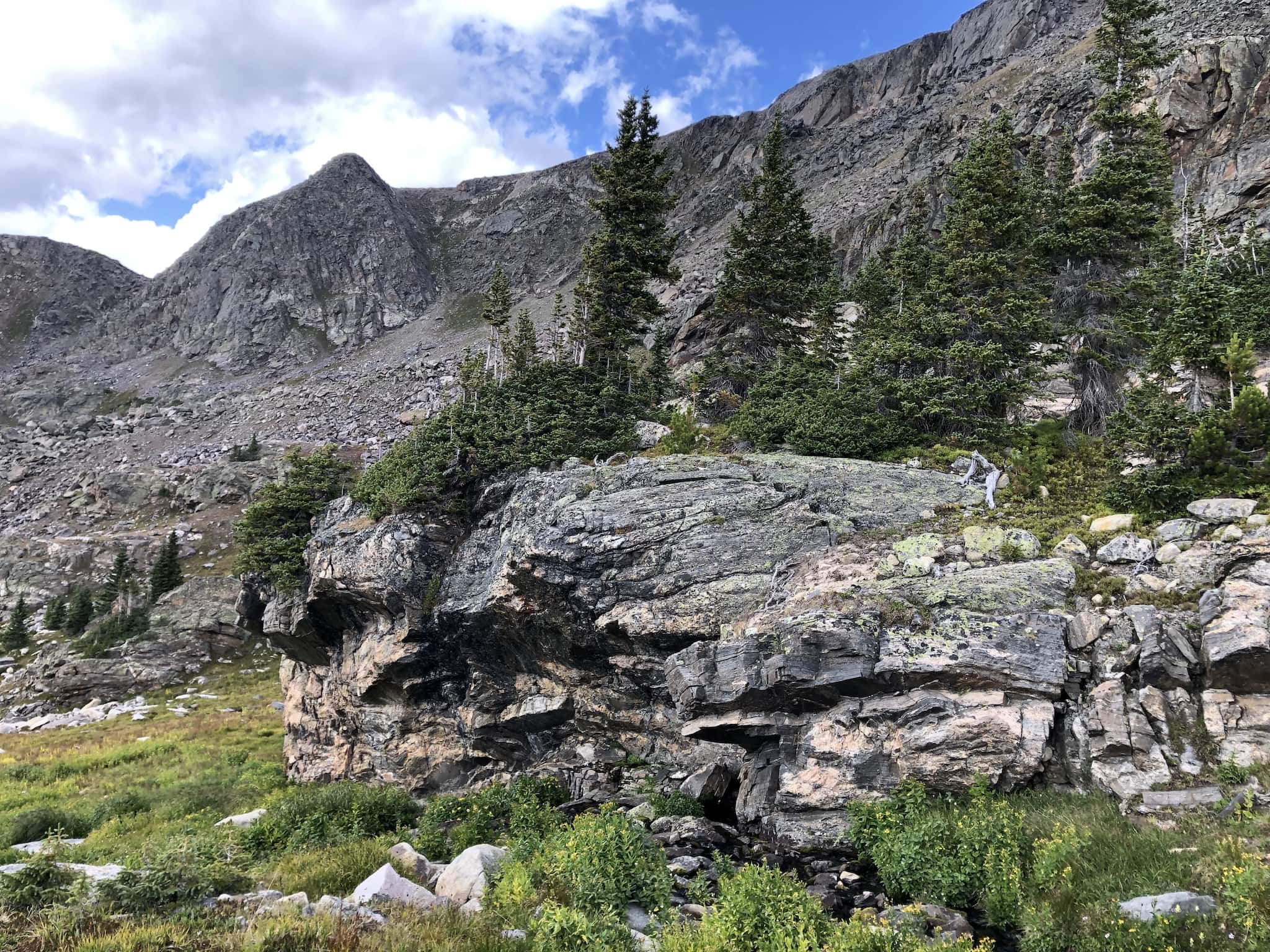 A large granite boulder in front of a granite mountain range