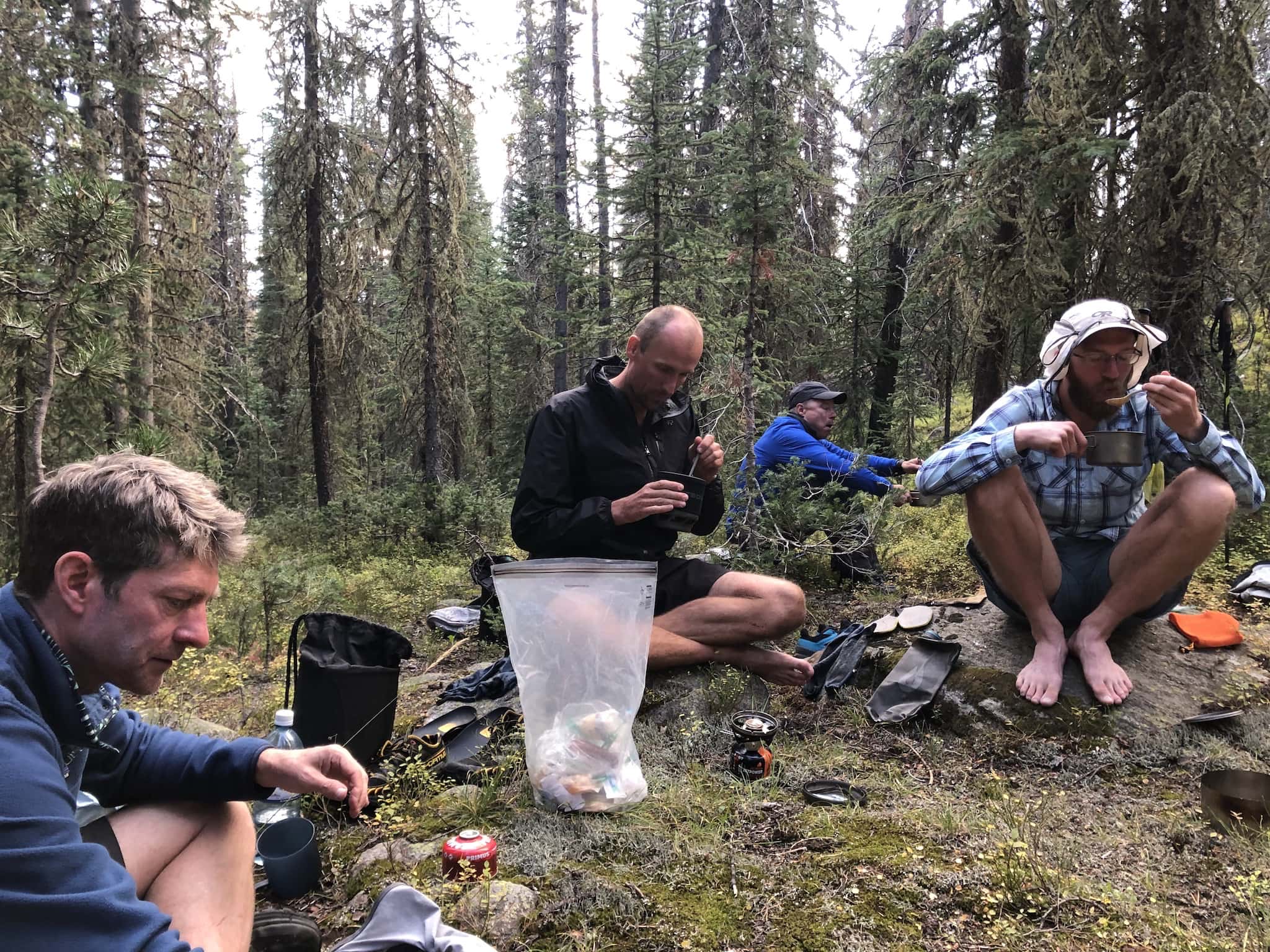 A group of men eating at a campsite