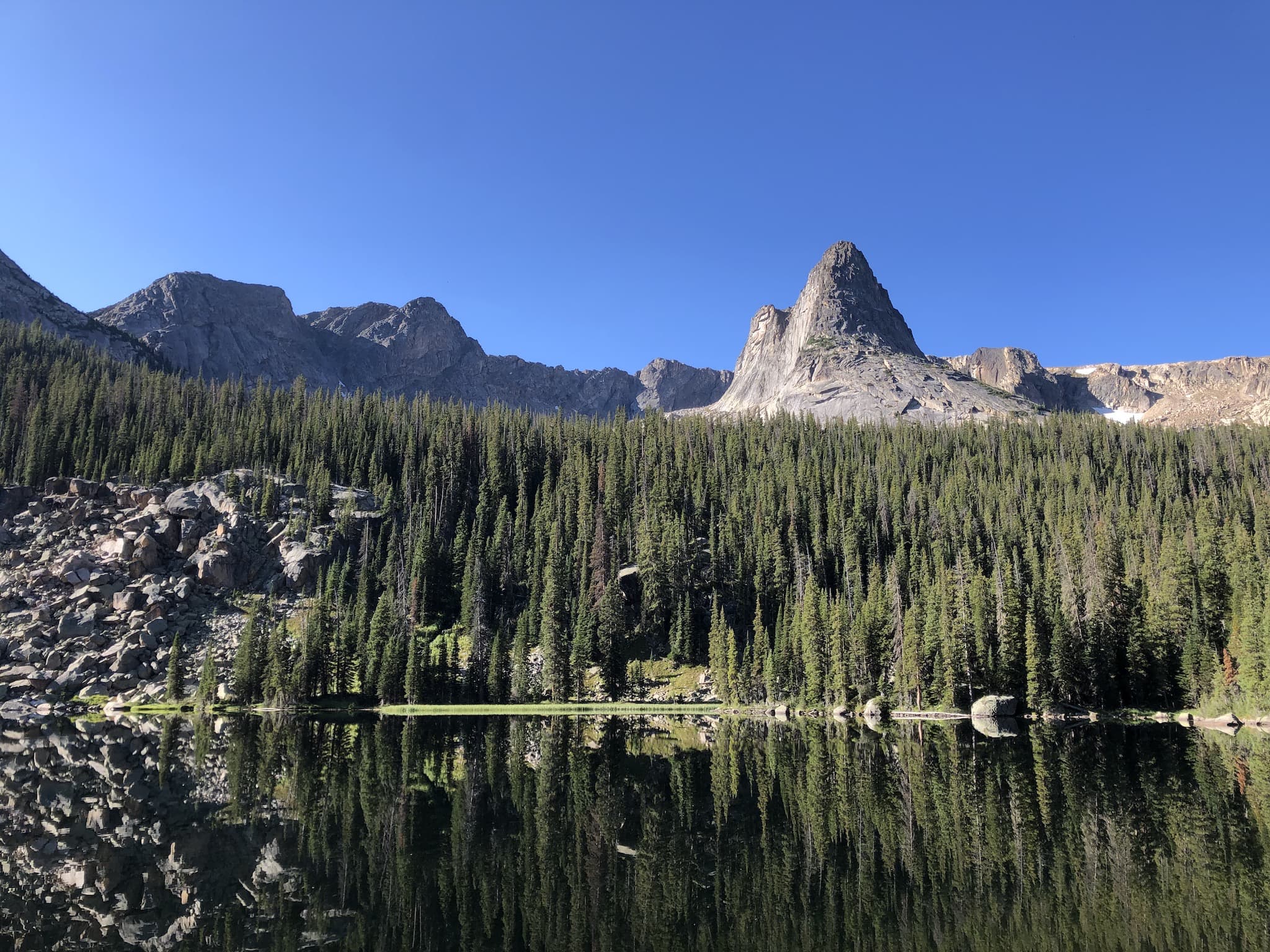 A calm lake reflecting an alpine landscape.