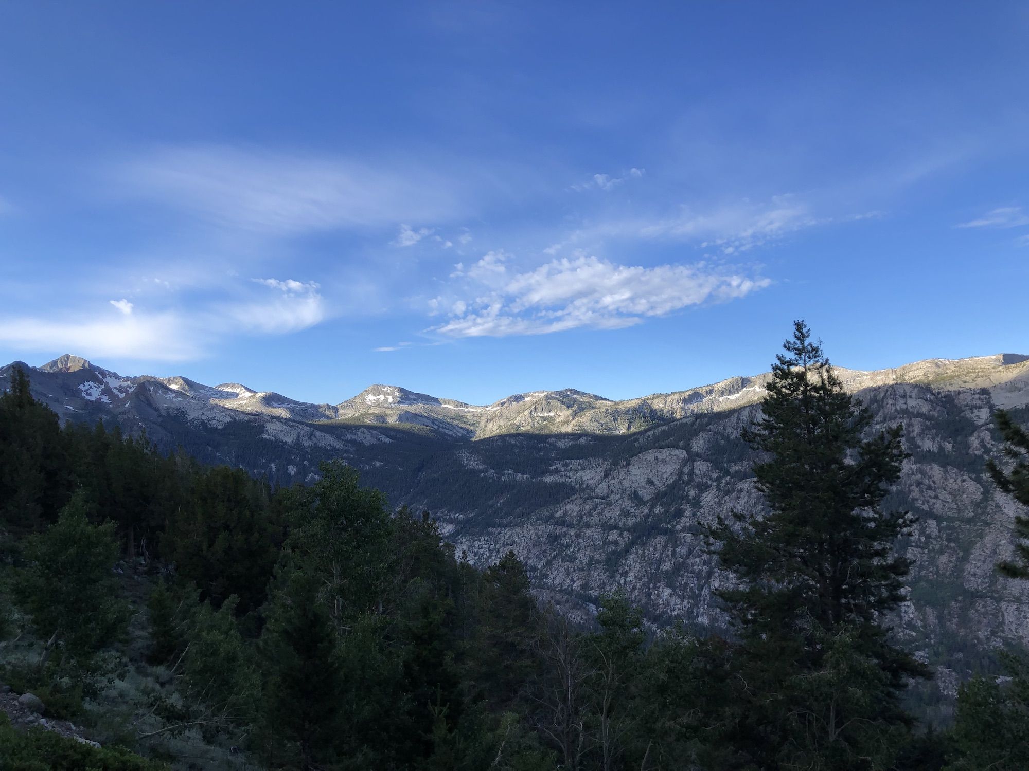 The tops of granite mountains are lit up by the sun.