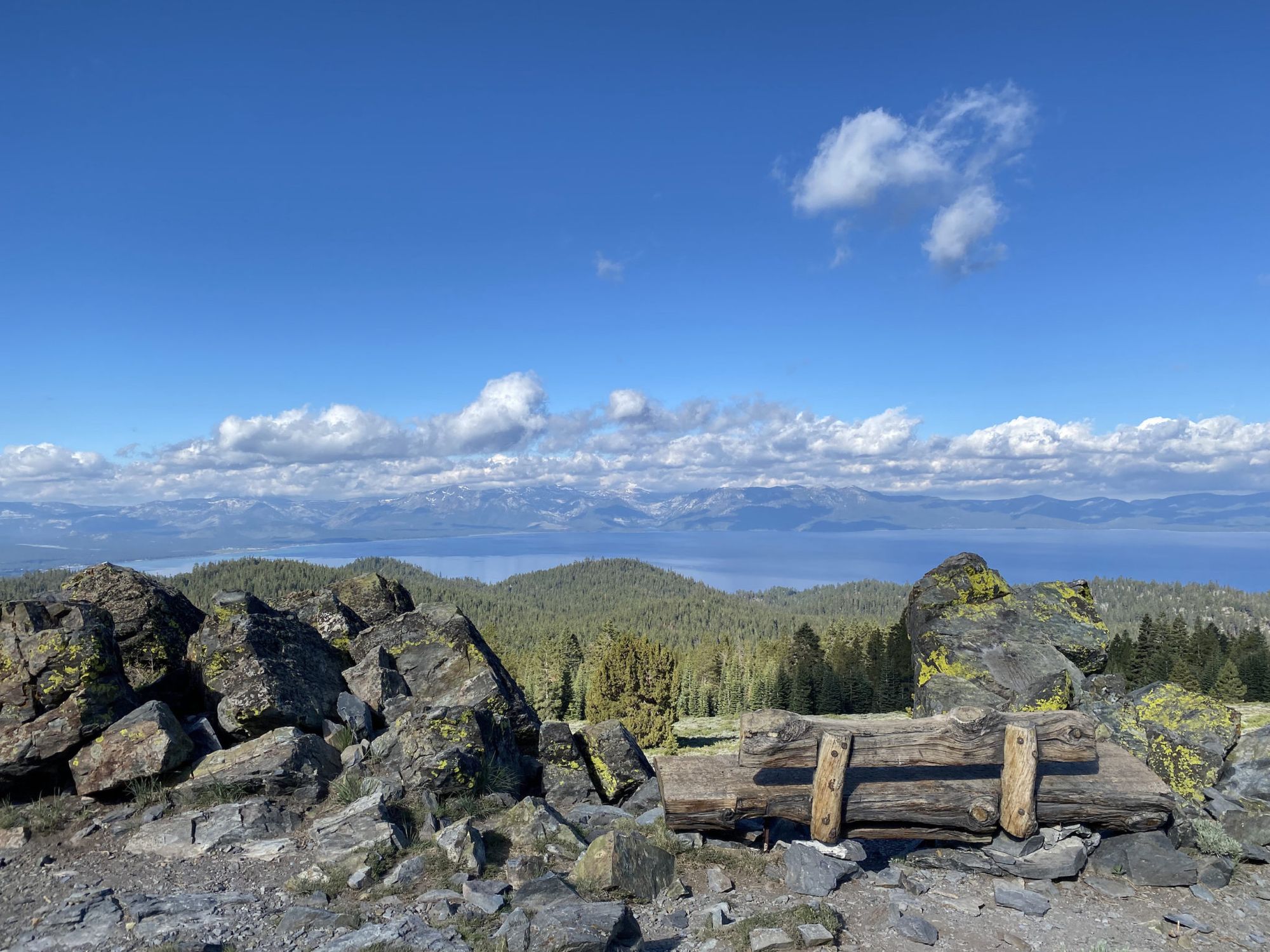 A wooden bench overlooking a lake far below