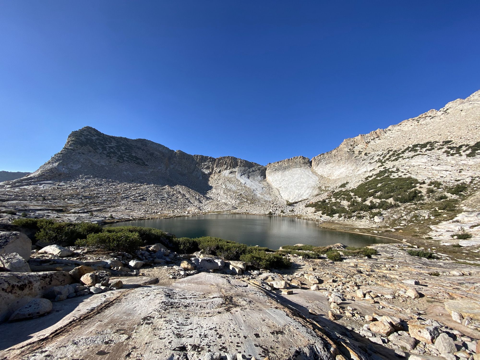 A small lake nestled among bare rock mountains.