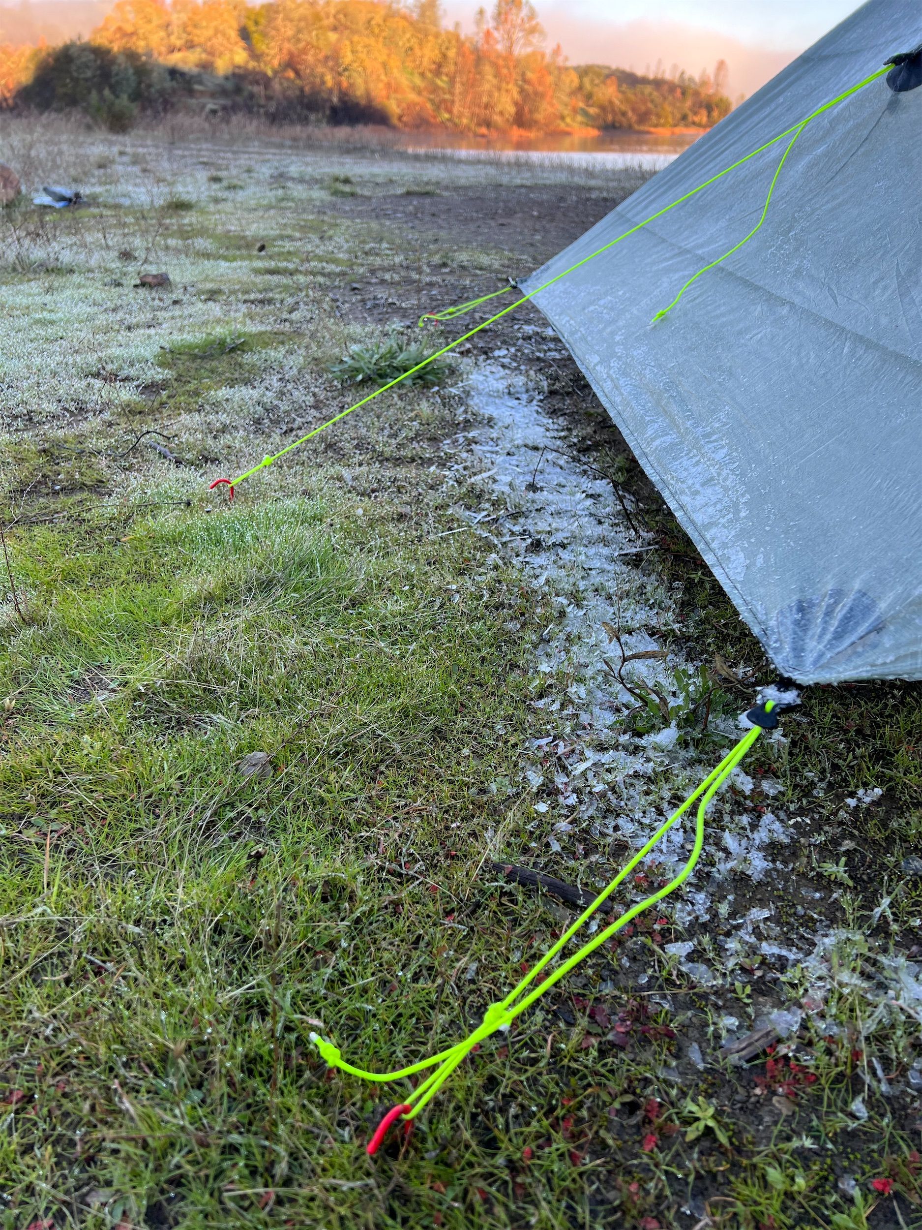 A pile of ice below a tent wall.