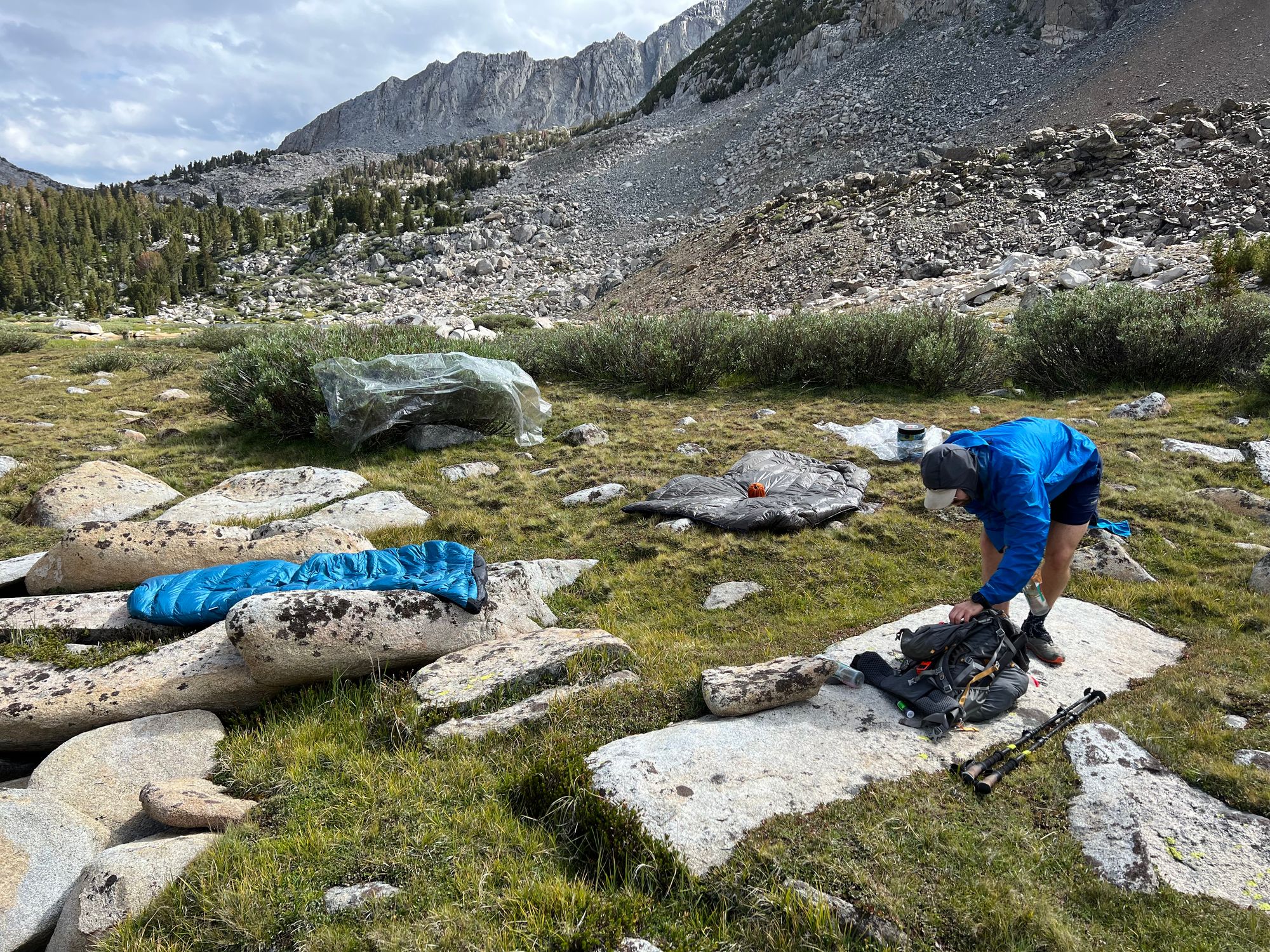 Sleeping bags and ground sheets drying out on the ground