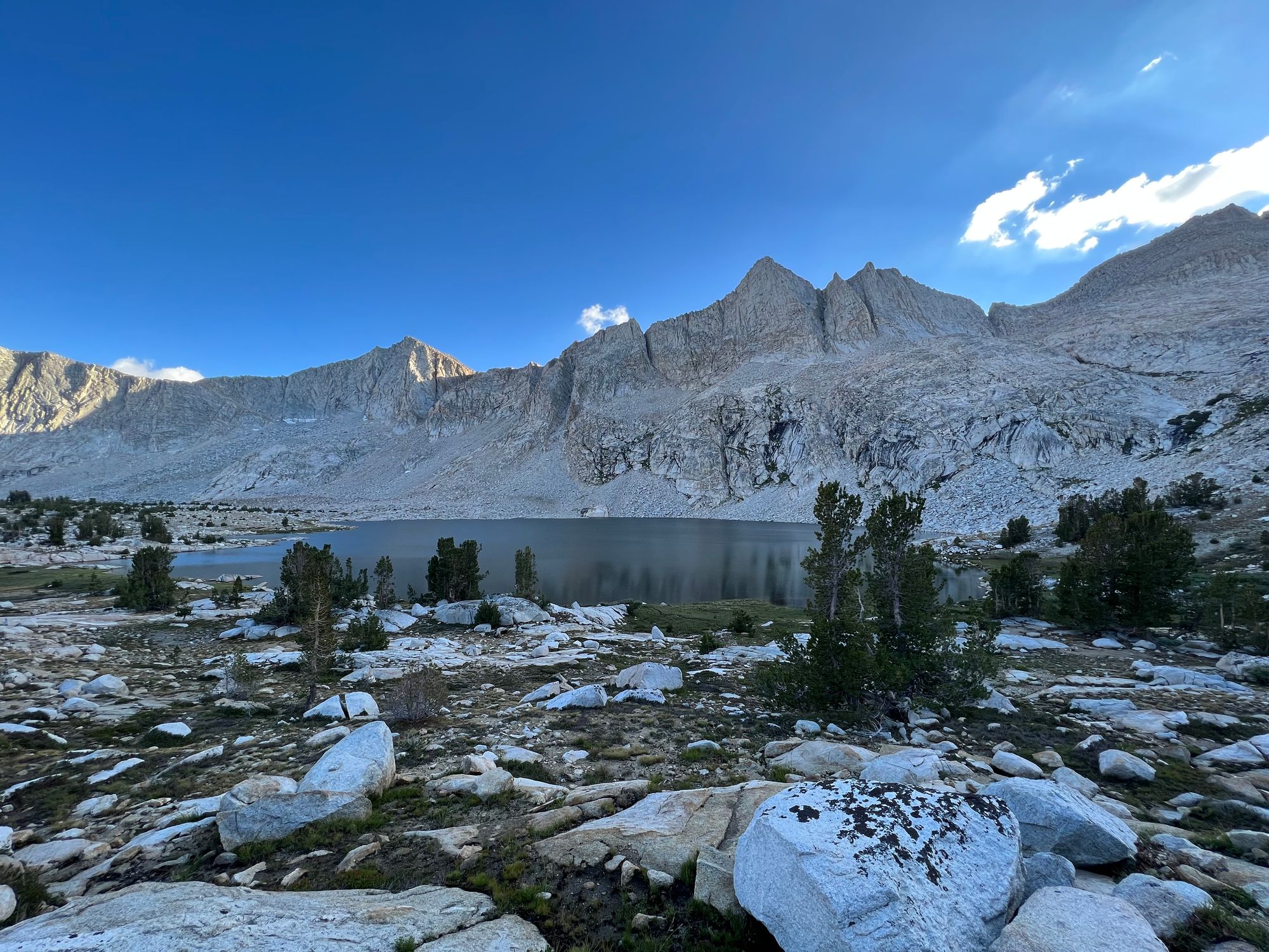A large lake in front of a near-vertical granite mountain.