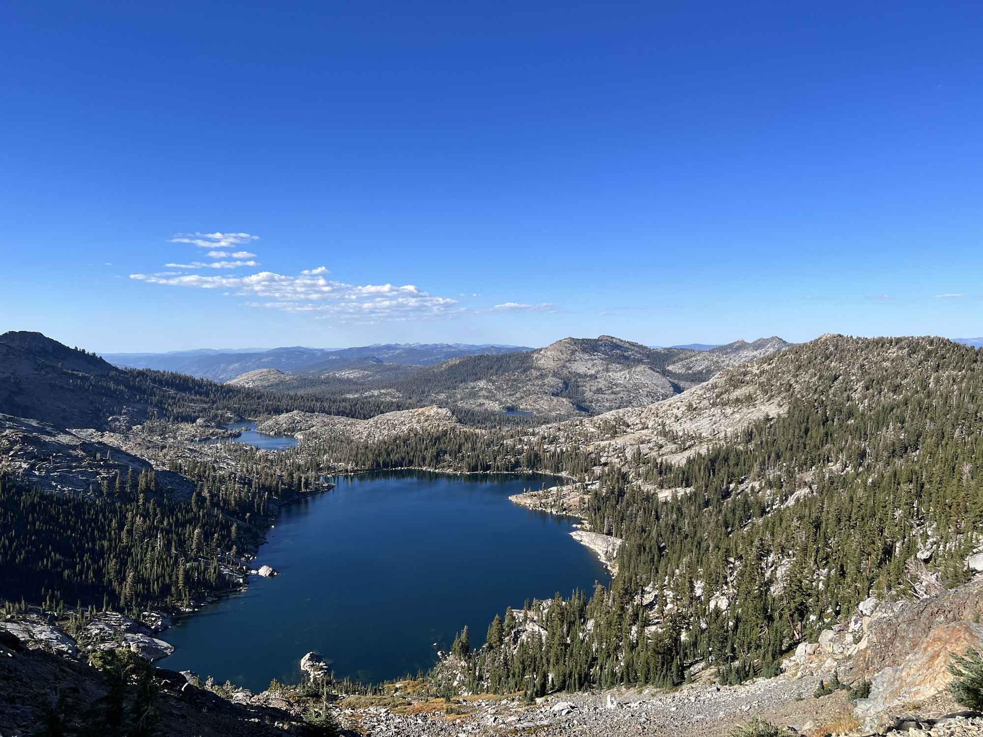 Two lakes nesteled in a granite valley with sparse forest.